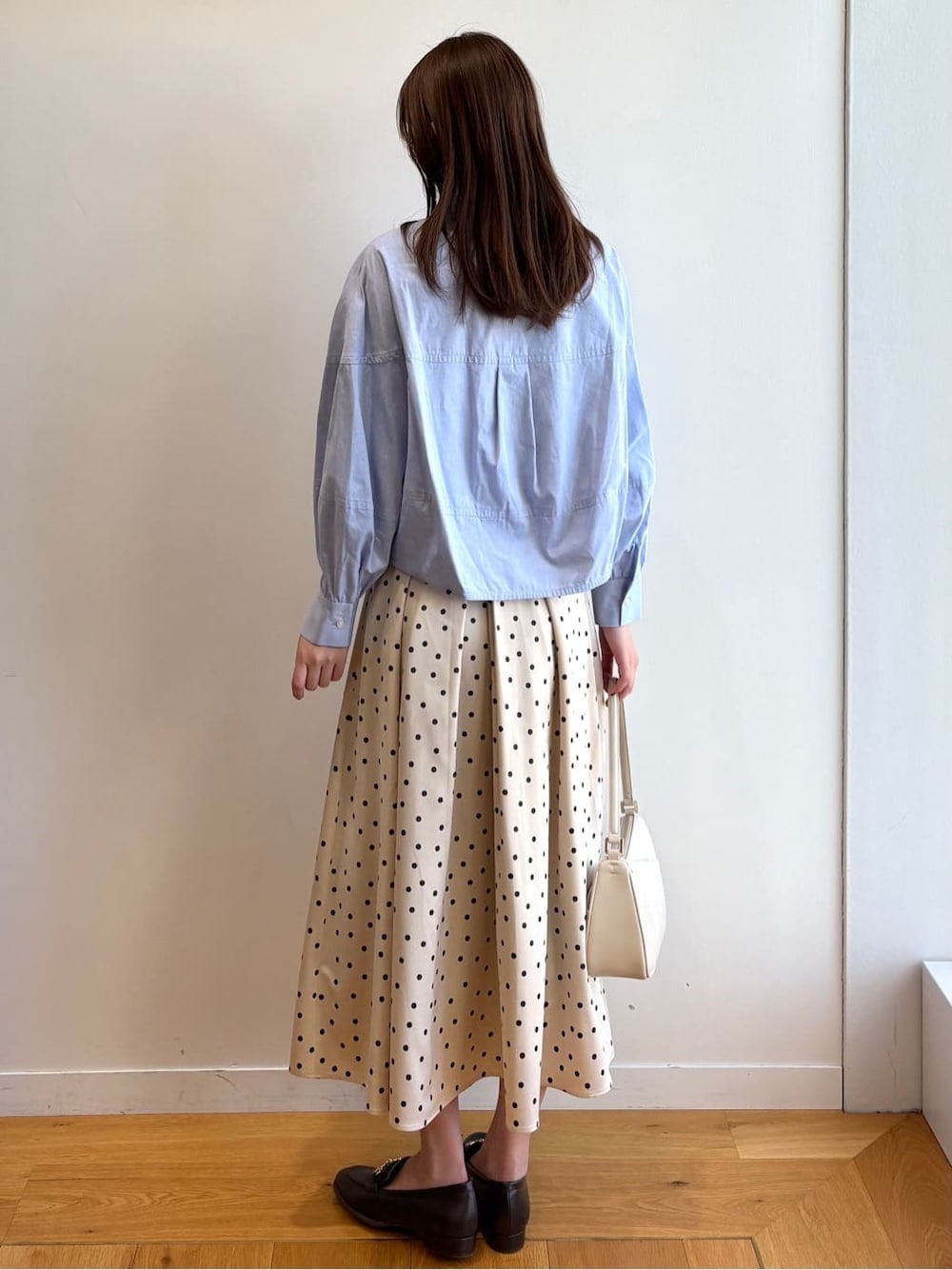 ブルー系のシャツ/ブラウス、ベージュ系のスカート、ホワイト系のショルダーバッグを着用したレディースの冬コーディネートの4枚目の写真