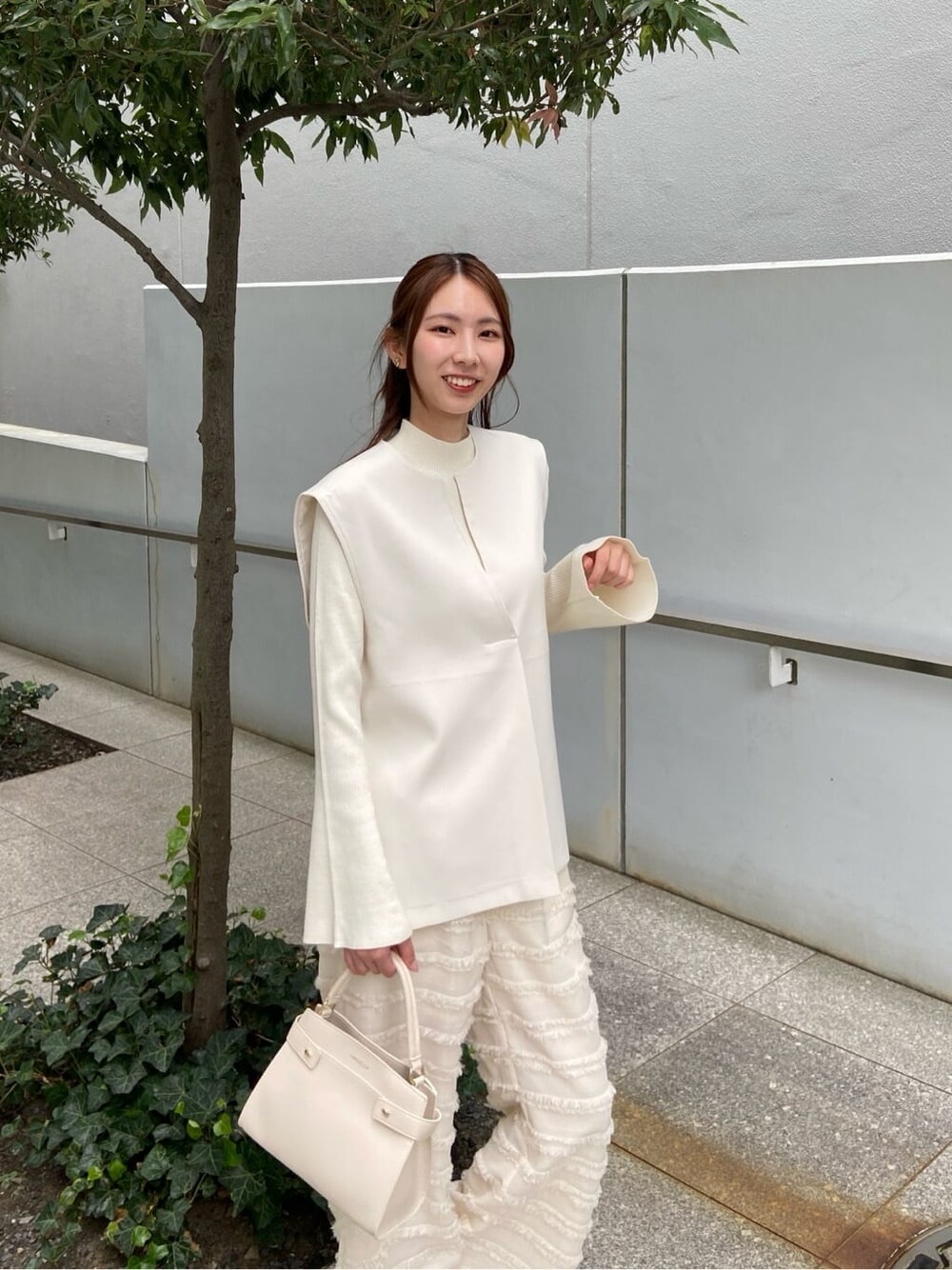 ホワイト系のその他パンツ、ホワイト系のショルダーバッグ、ベージュ系のブーツを着用したレディースの秋コーディネートの8枚目の写真