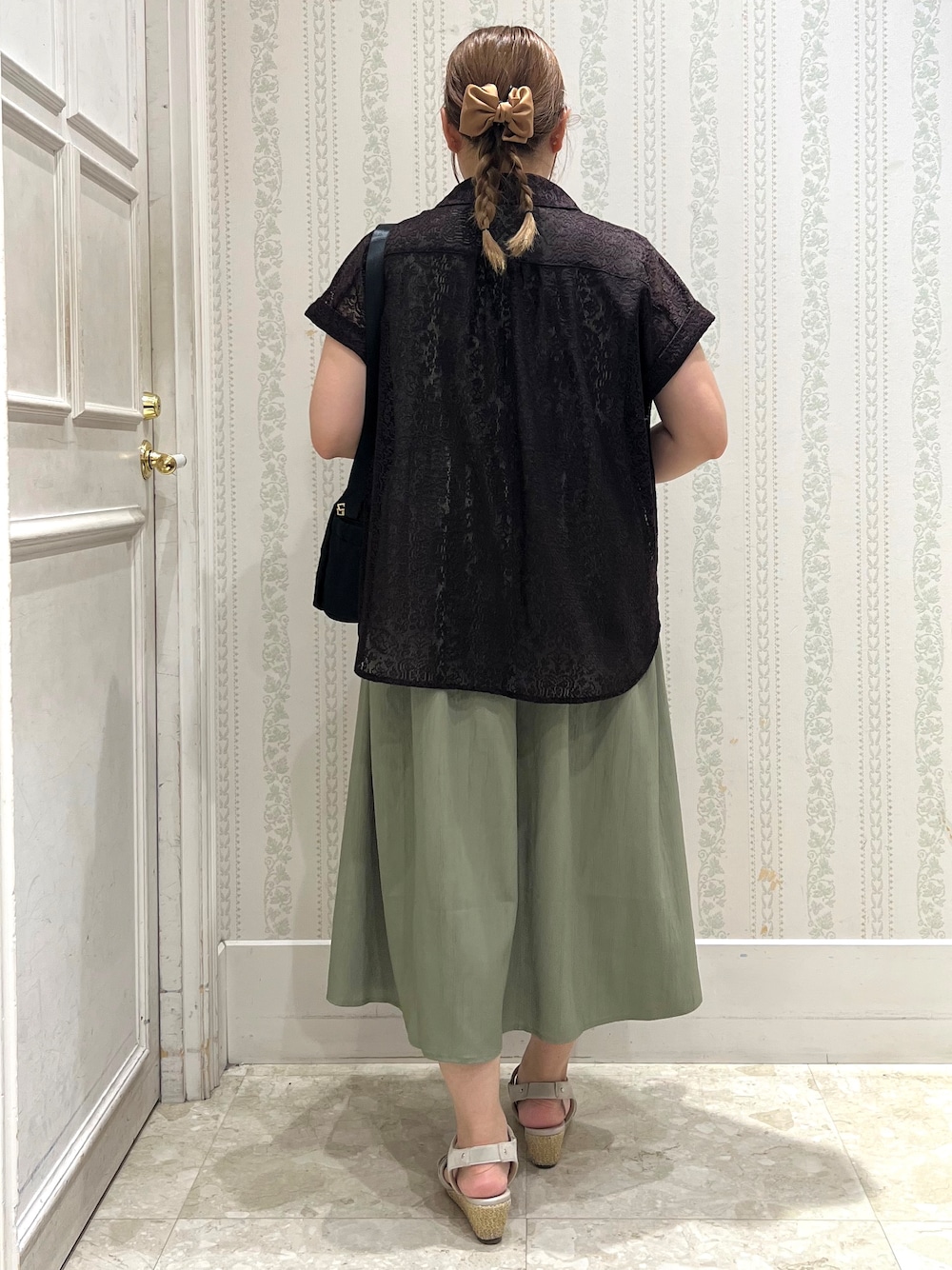 ブラウン系のシャツ/ブラウス、グリーン系のワンピース、ブラック系のショルダーバッグを着用したレディースの夏コーディネートの3枚目の写真
