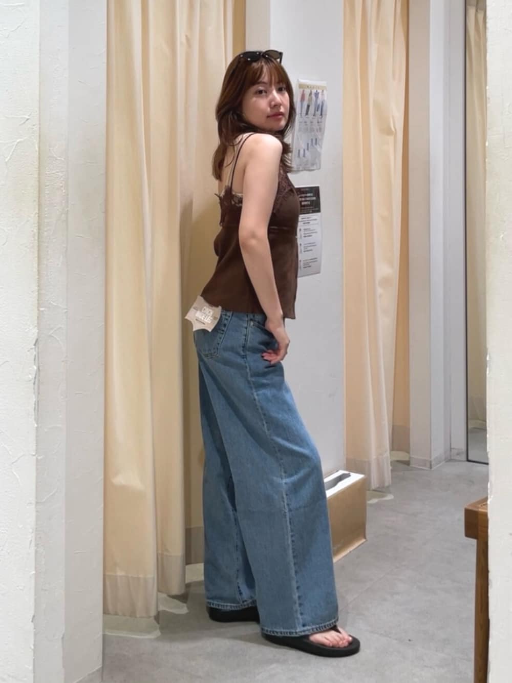 ブルー系のデニムパンツ、ホワイト系のショルダーバッグ、ブラウン系のTシャツ/カットソーを着用したレディースの夏コーディネートの2枚目の写真