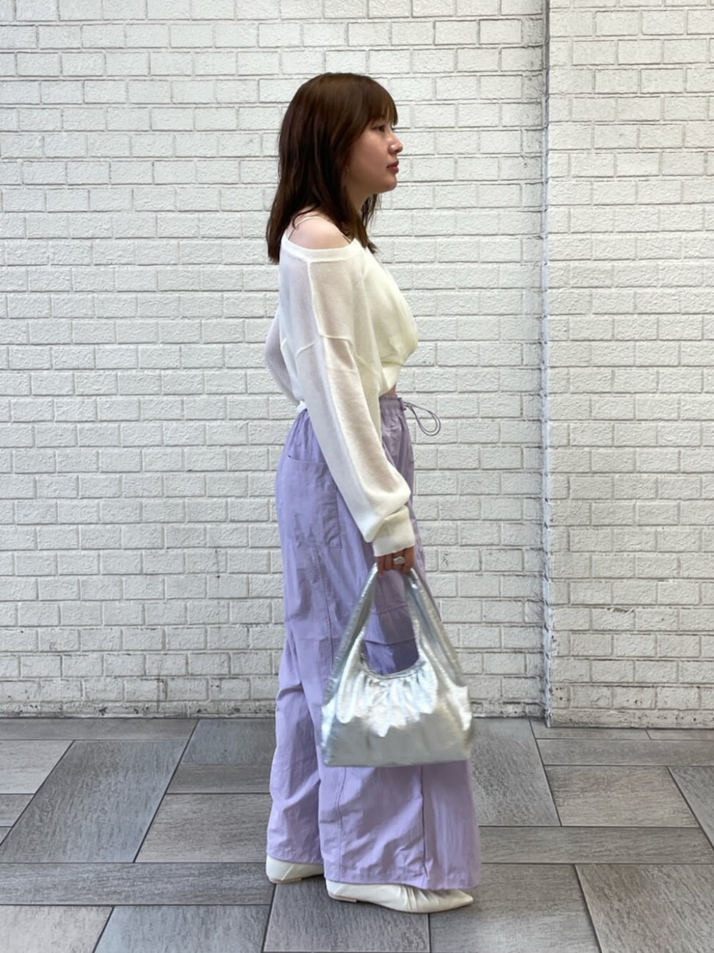ホワイト系のパンプス、シルバー系のハンドバッグ、ホワイト系のキャミソールを着用したレディースの夏コーディネートの2枚目の写真