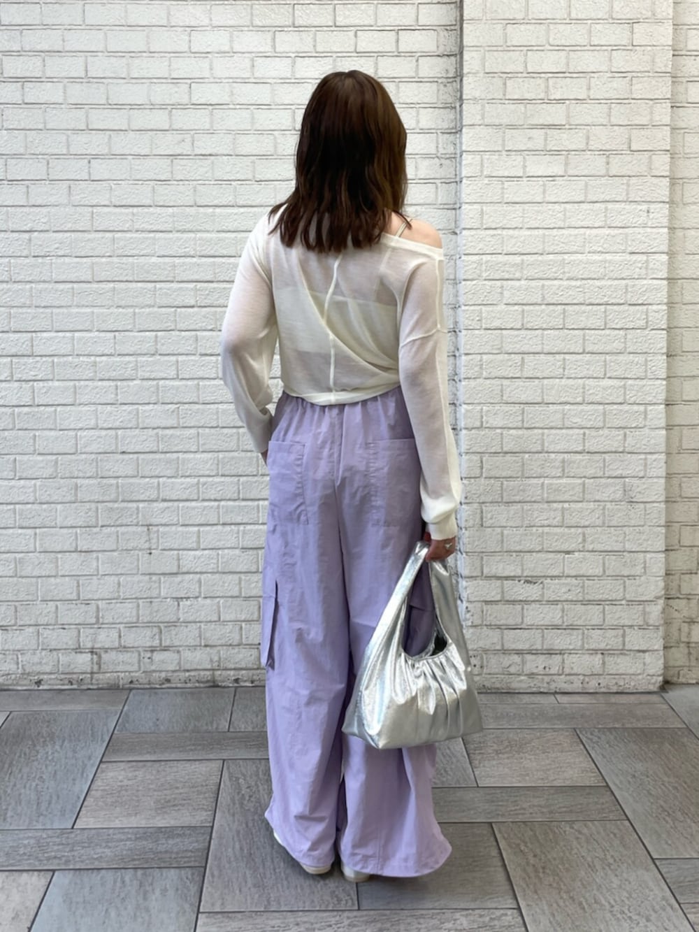 ホワイト系のパンプス、シルバー系のハンドバッグ、ホワイト系のキャミソールを着用したレディースの夏コーディネートの3枚目の写真