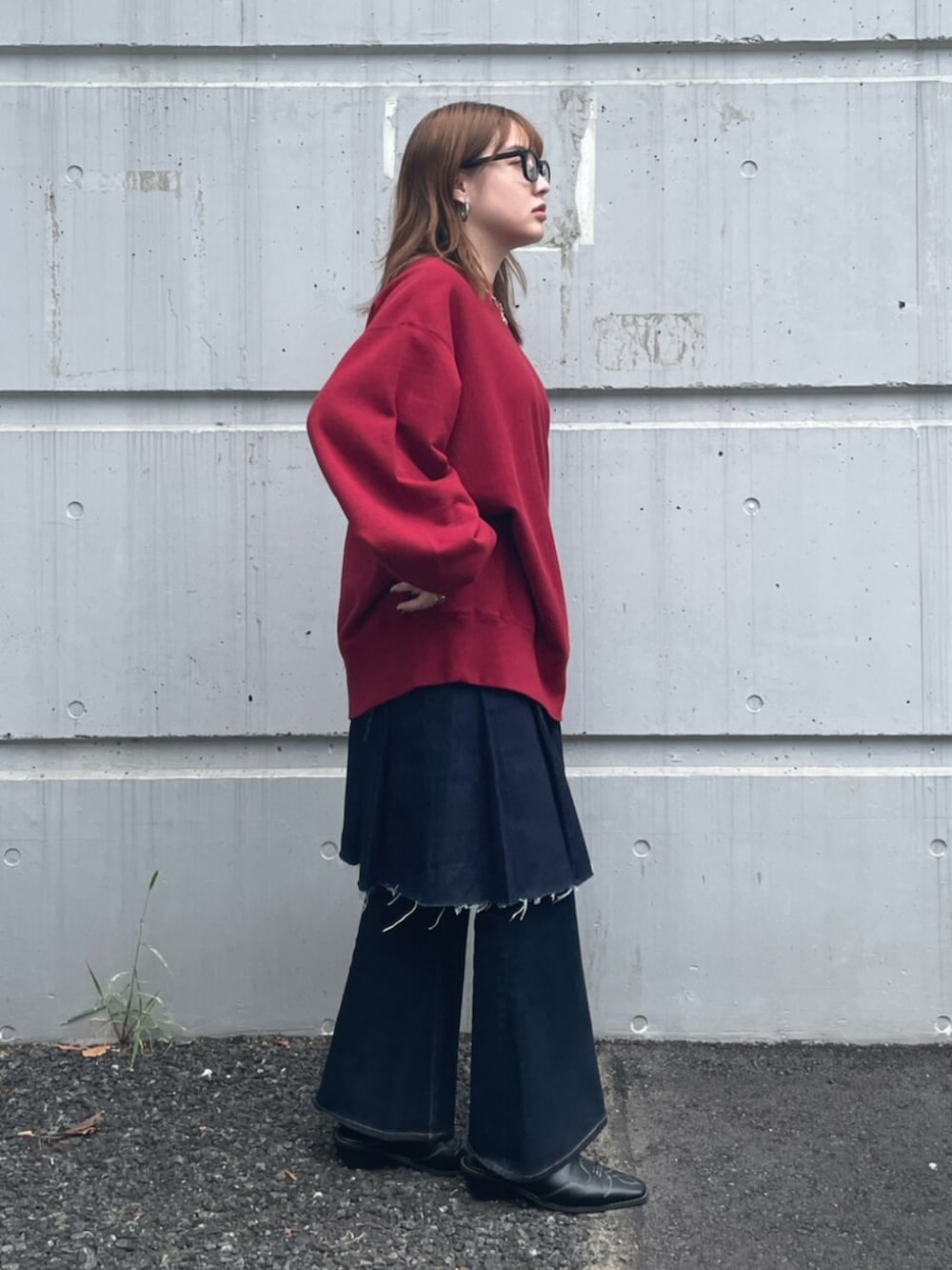 ブラック系のその他シューズ、ブルー系のデニムパンツ、レッド系のスウェットを着用したレディースの秋コーディネートの2枚目の写真