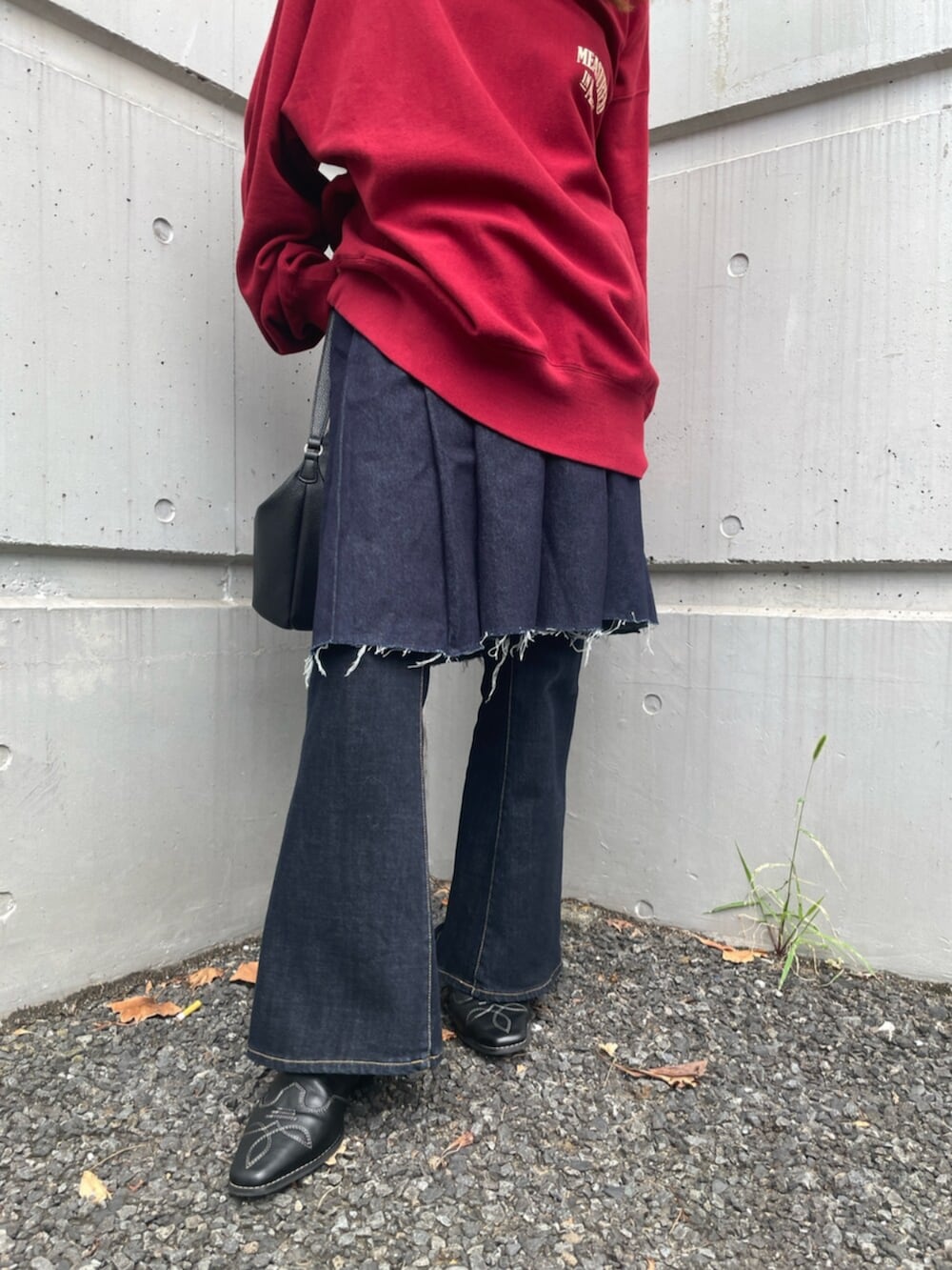 ブラック系のその他シューズ、ブルー系のデニムパンツ、レッド系のスウェットを着用したレディースの秋コーディネートの5枚目の写真