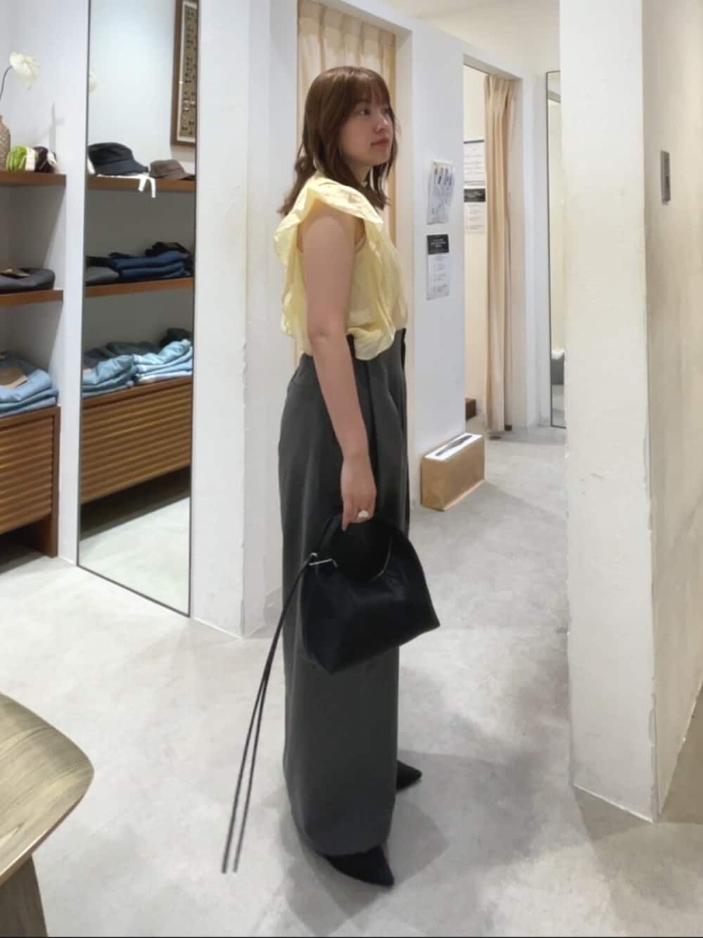 ブラック系のパンプス、ブラック系のハンドバッグ、グレー系のその他パンツを着用したレディースの夏コーディネートの2枚目の写真