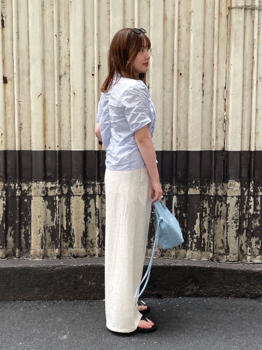ホワイト系のその他パンツ、ブルー系のシャツ/ブラウス、ブルー系のハンドバッグを着用したレディースの夏コーディネートの2枚目の写真