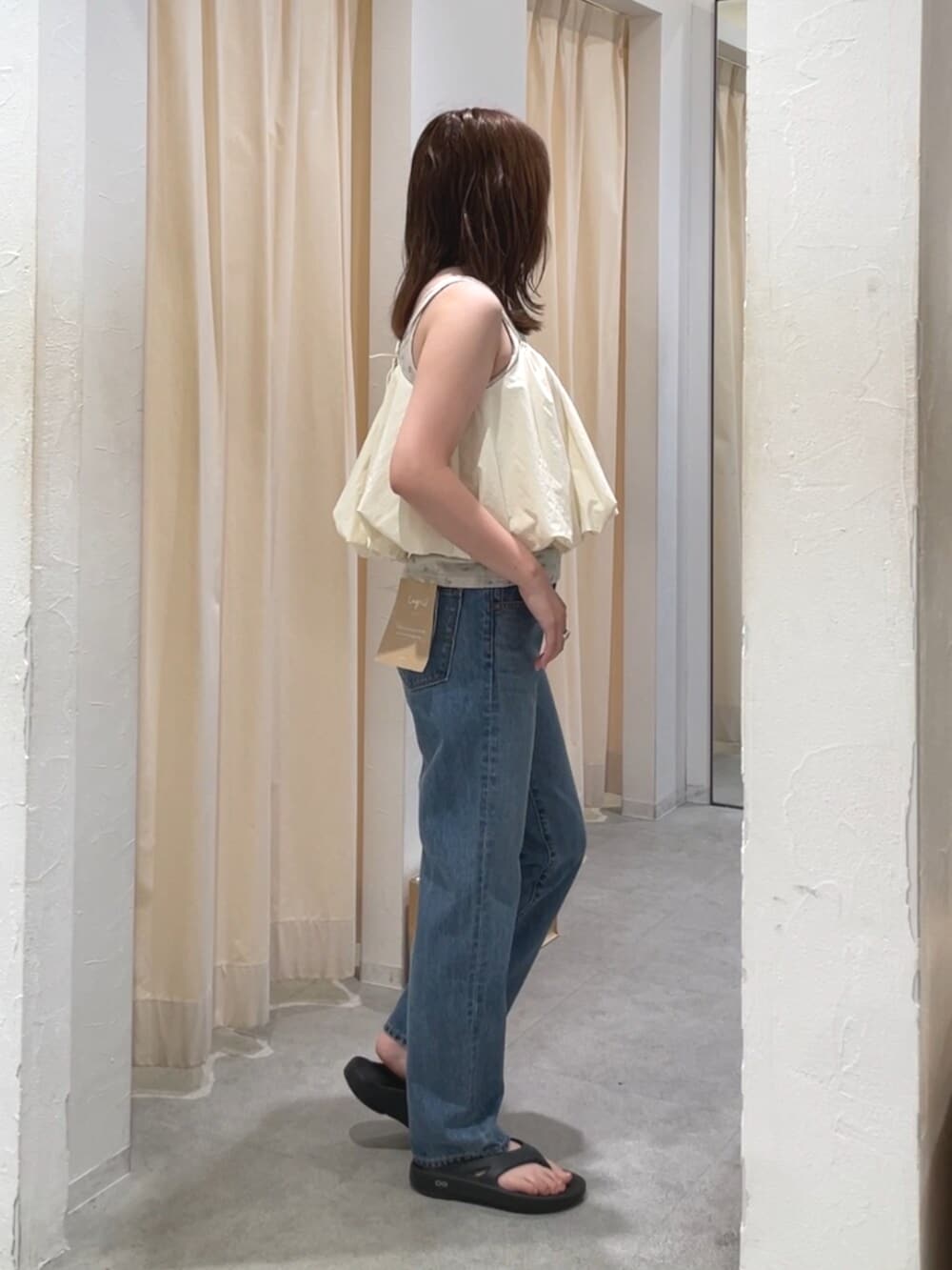 グレー系のキャミソール、ブルー系のデニムパンツ、ホワイト系のキャミソールを着用したレディースの夏コーディネートの2枚目の写真