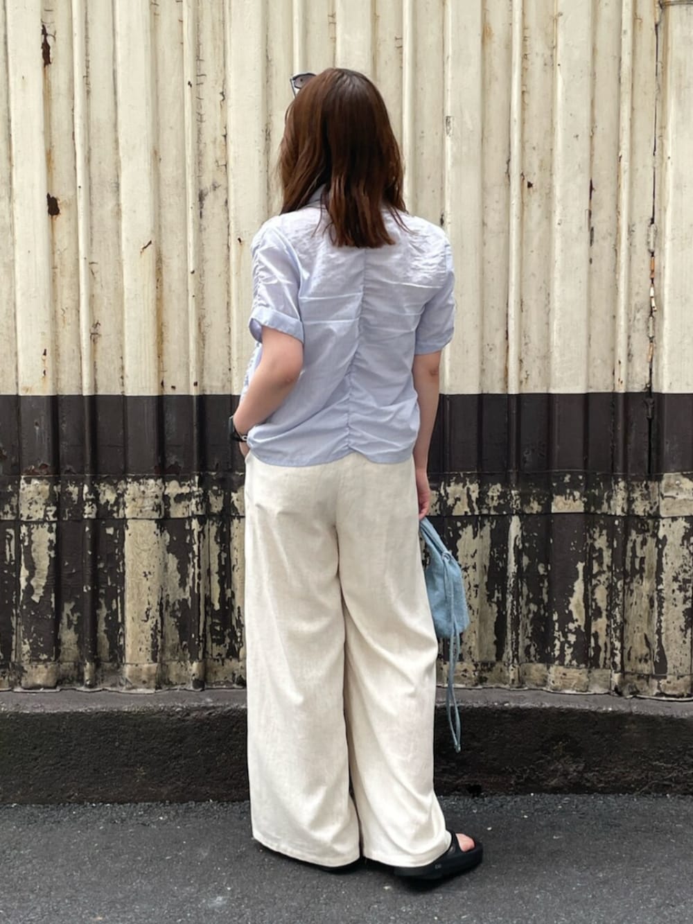 ホワイト系のその他パンツ、ブルー系のシャツ/ブラウス、ブルー系のハンドバッグを着用したレディースの夏コーディネートの3枚目の写真