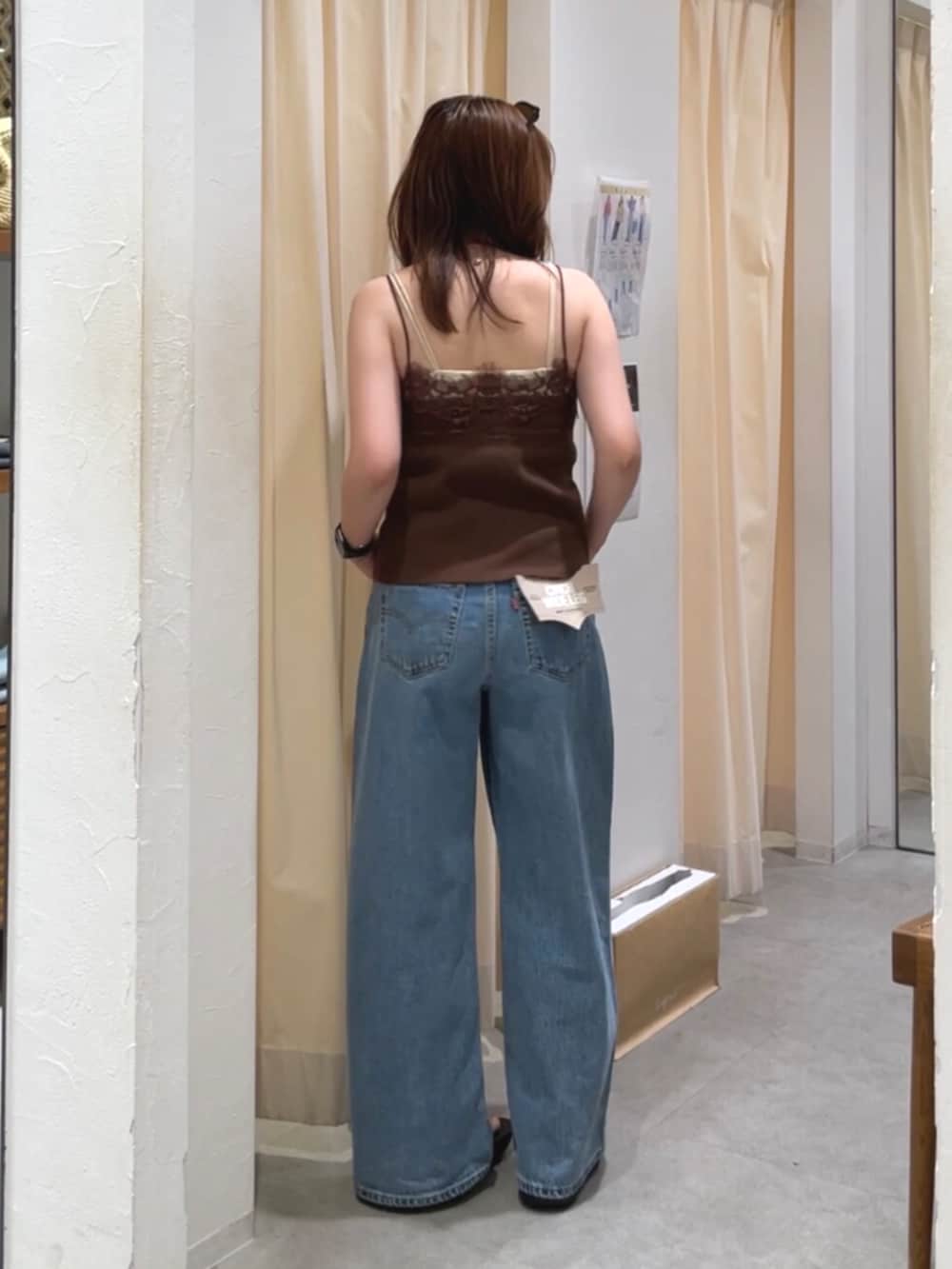 ブルー系のデニムパンツ、ホワイト系のショルダーバッグ、ブラウン系のTシャツ/カットソーを着用したレディースの夏コーディネートの3枚目の写真