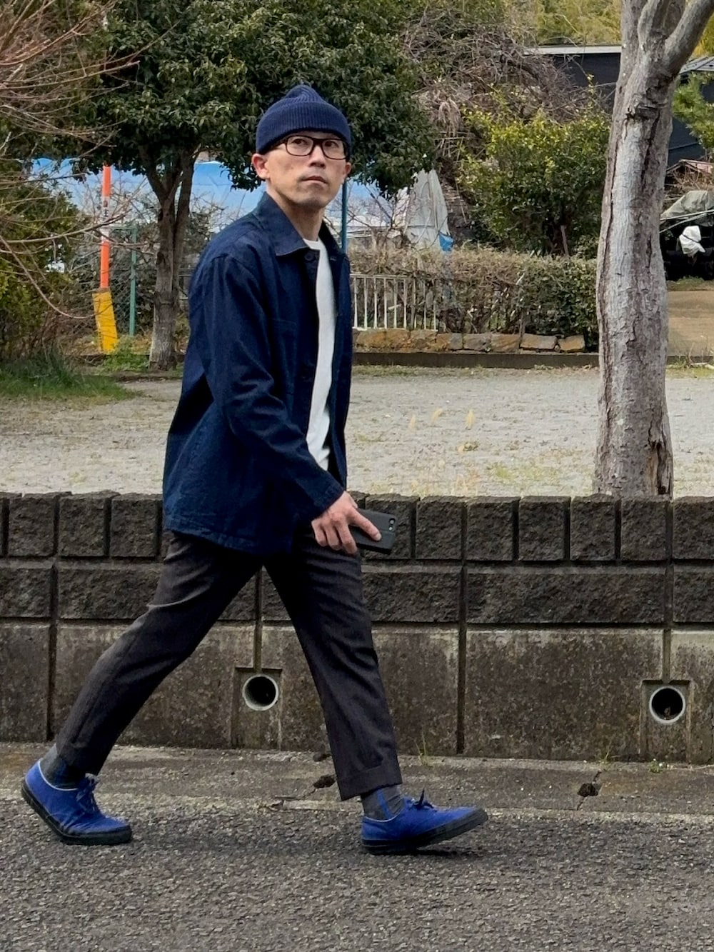 ブルー系のスニーカー、ブルー系のニットキャップ/ビーニー、ブラウン系のメガネを着用したメンズの春コーディネートの2枚目の写真