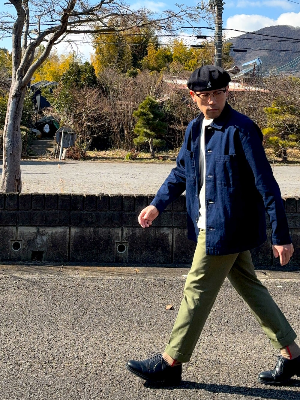 ブラック系のドレスシューズ、ブラウン系のメガネを着用したメンズの冬コーディネートの2枚目の写真