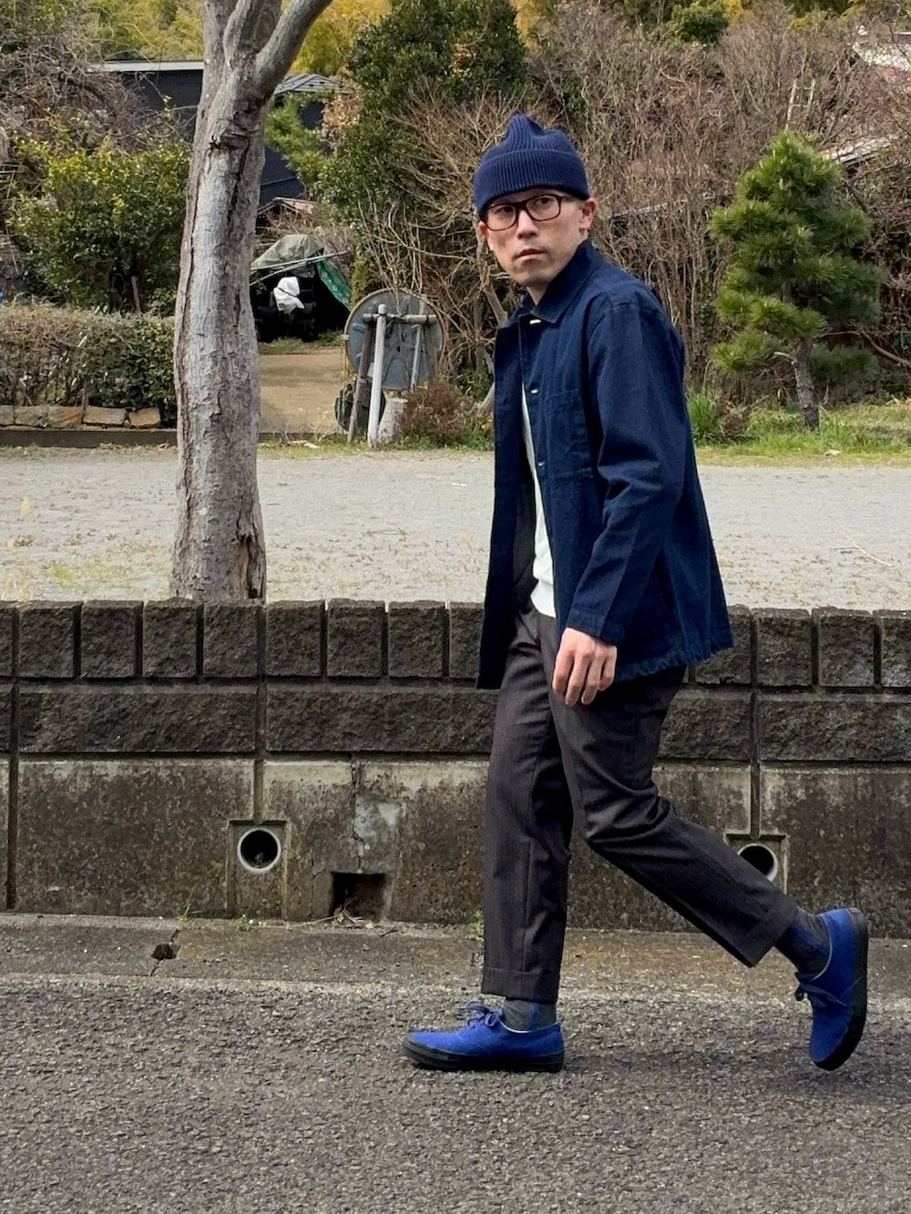 ブルー系のスニーカー、ブルー系のニットキャップ/ビーニー、ブラウン系のメガネを着用したメンズの春コーディネートの3枚目の写真