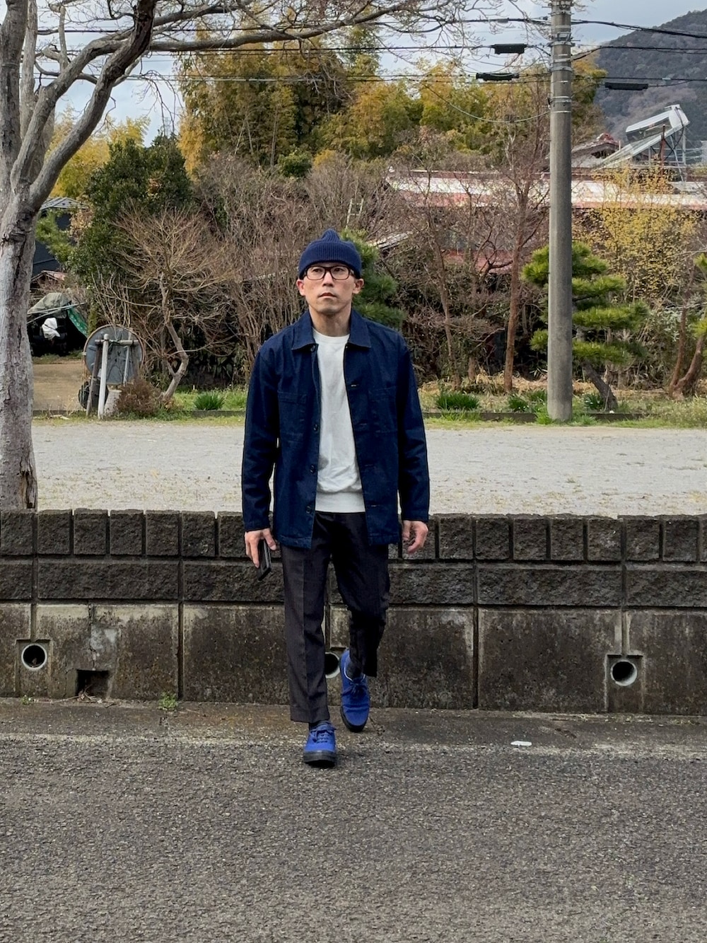 ブルー系のスニーカー、ブルー系のニットキャップ/ビーニー、ブラウン系のメガネを着用したメンズの春コーディネートの4枚目の写真