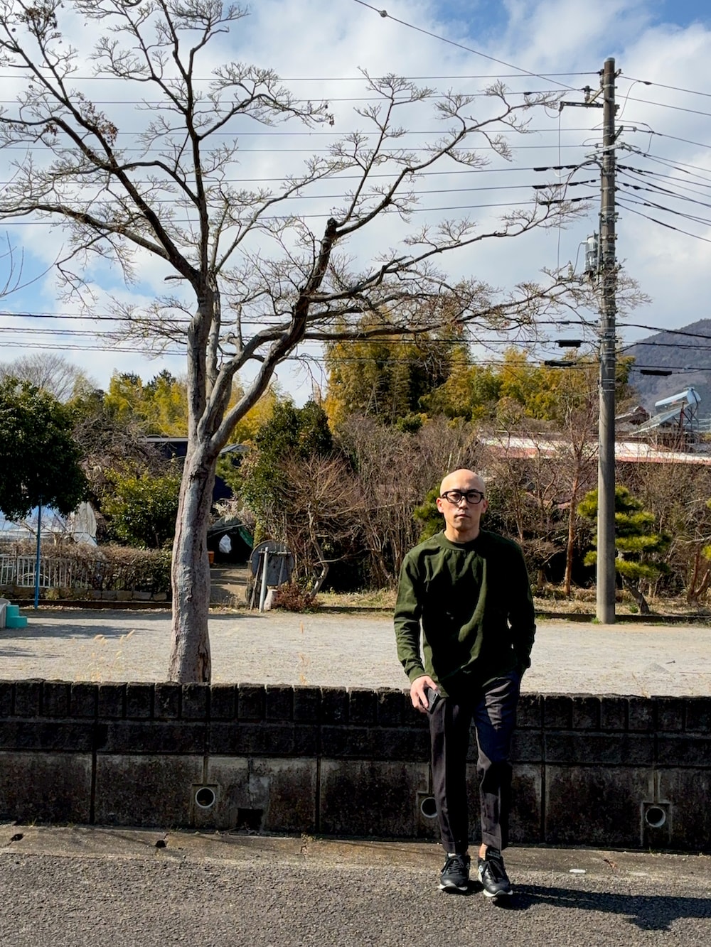 グリーン系のTシャツ/カットソー、ブラック系のスニーカー、ブラック系のメガネを着用したメンズの冬コーディネートの3枚目の写真