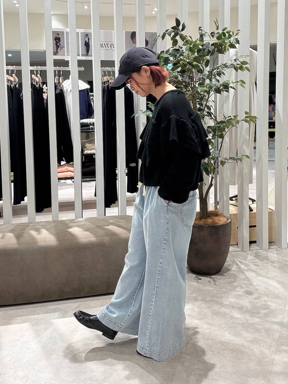 ブルー系のデニムパンツ、ブラック系のニット/セーター、ブラック系のローファーを着用したレディースの冬コーディネートの2枚目の写真