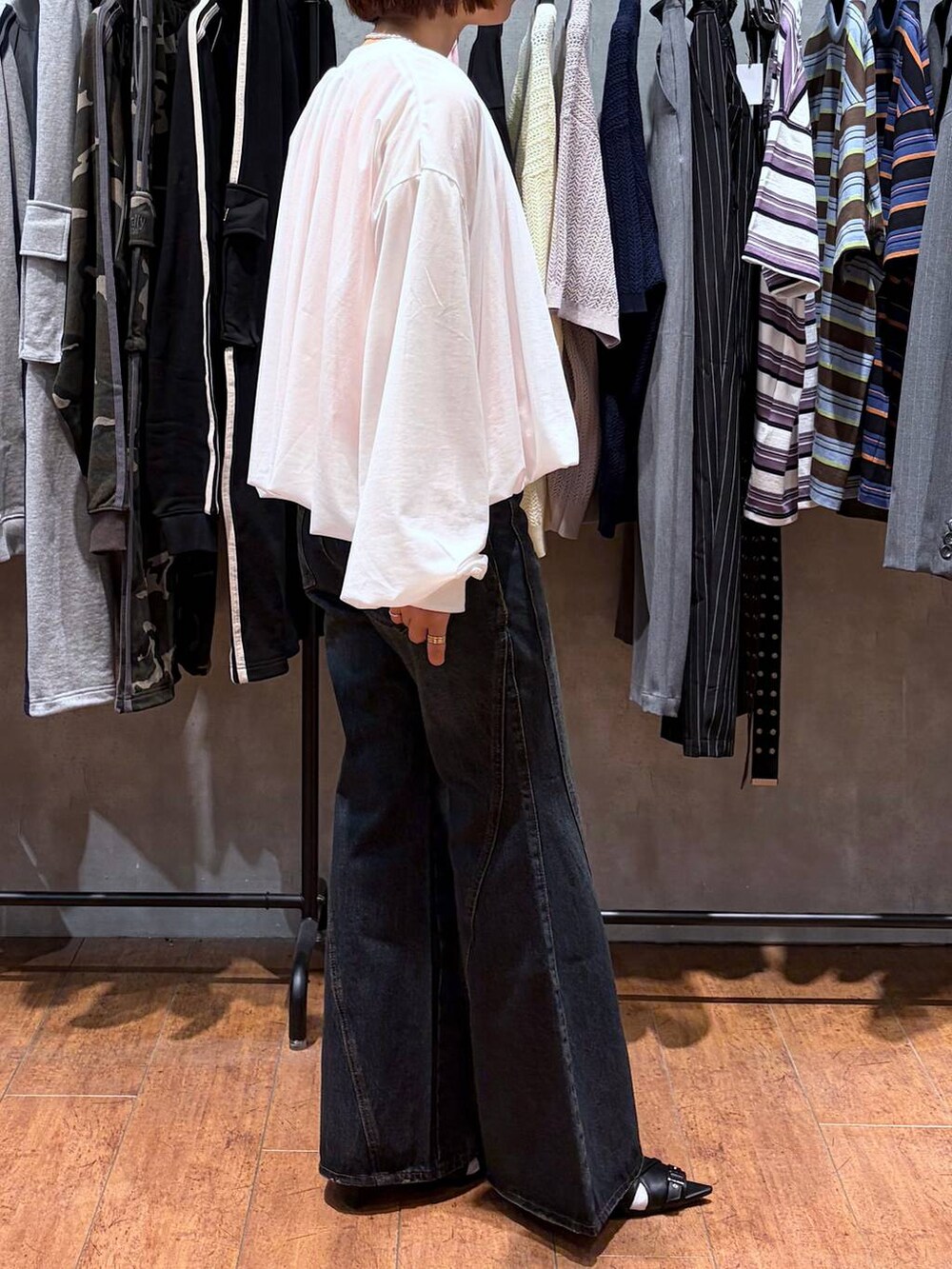 ブルー系のデニムパンツ、ホワイト系のブルゾン、ブラック系のサンダルを着用したレディースの春コーディネートの8枚目の写真