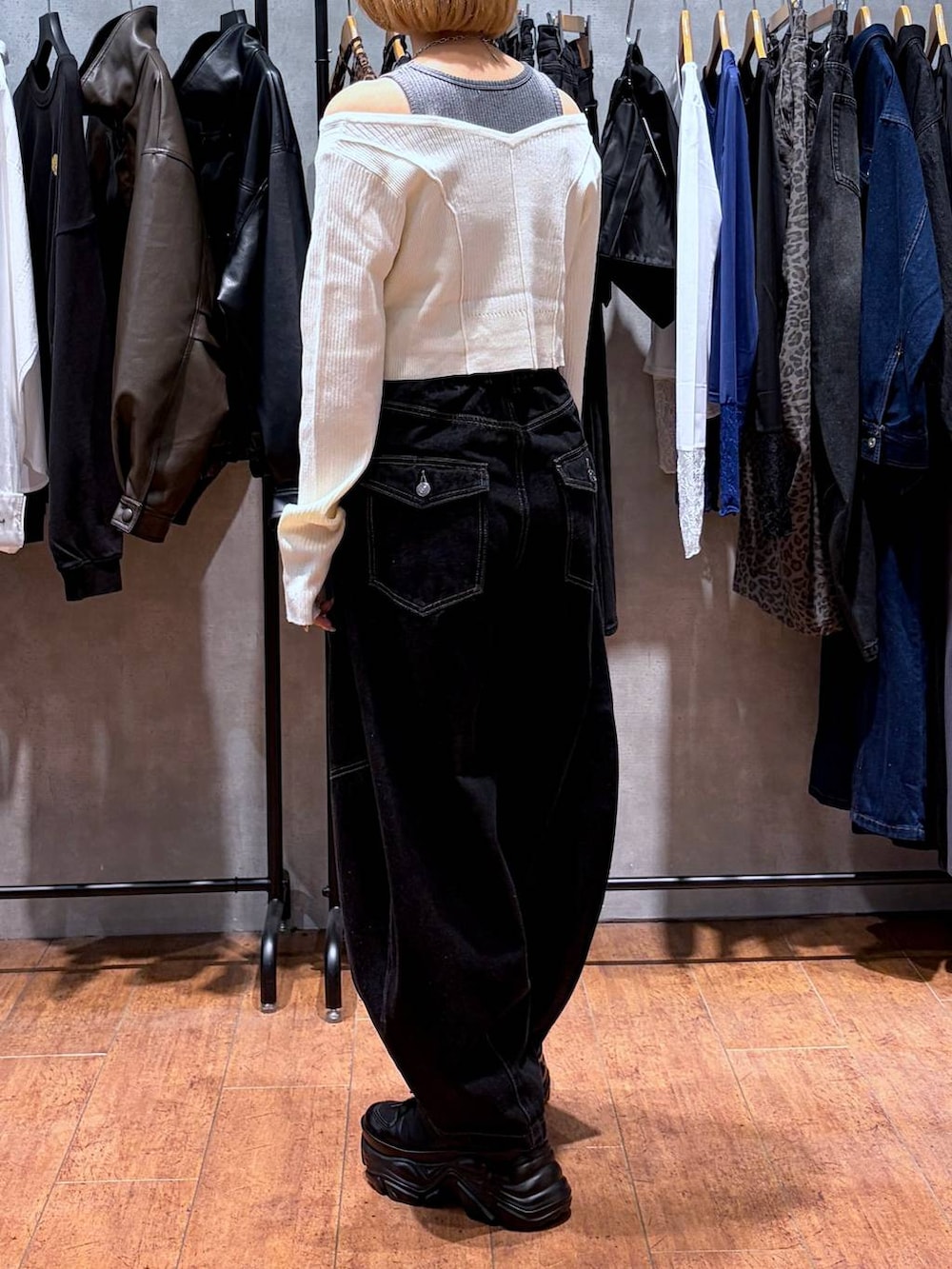 ブラック系のデニムパンツ、ブラック系のスニーカー、ホワイト系のニット/セーターを着用したレディースの秋コーディネートの3枚目の写真