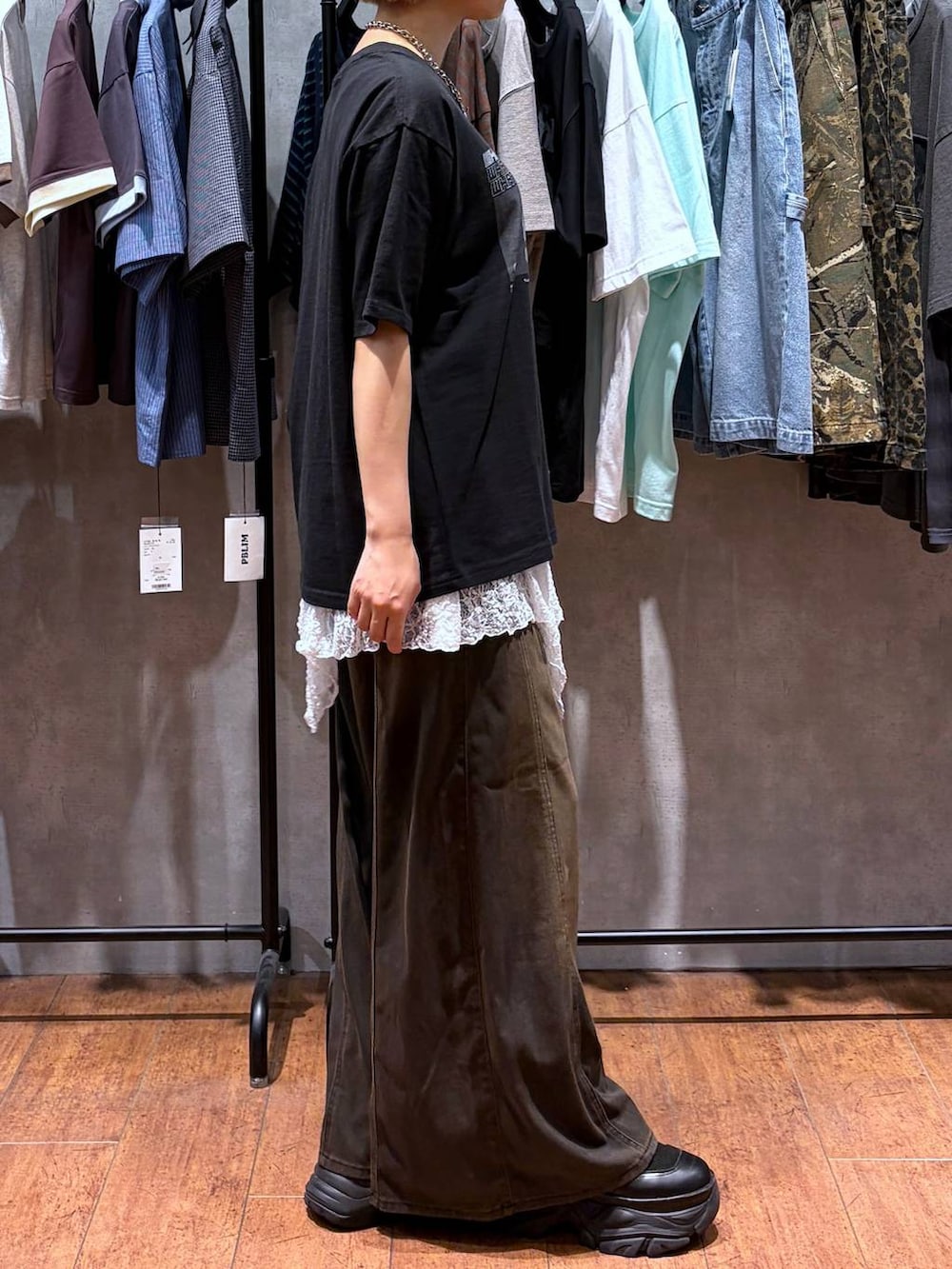 ブラウン系のデニムパンツ、ブラック系のTシャツ/カットソー、ブラック系のブーツを着用したレディースの夏コーディネートの7枚目の写真