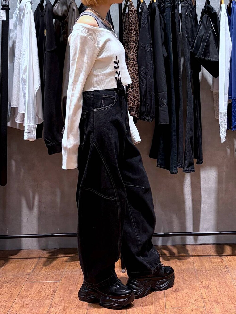 ブラック系のデニムパンツ、ブラック系のスニーカー、ホワイト系のニット/セーターを着用したレディースの秋コーディネートの5枚目の写真
