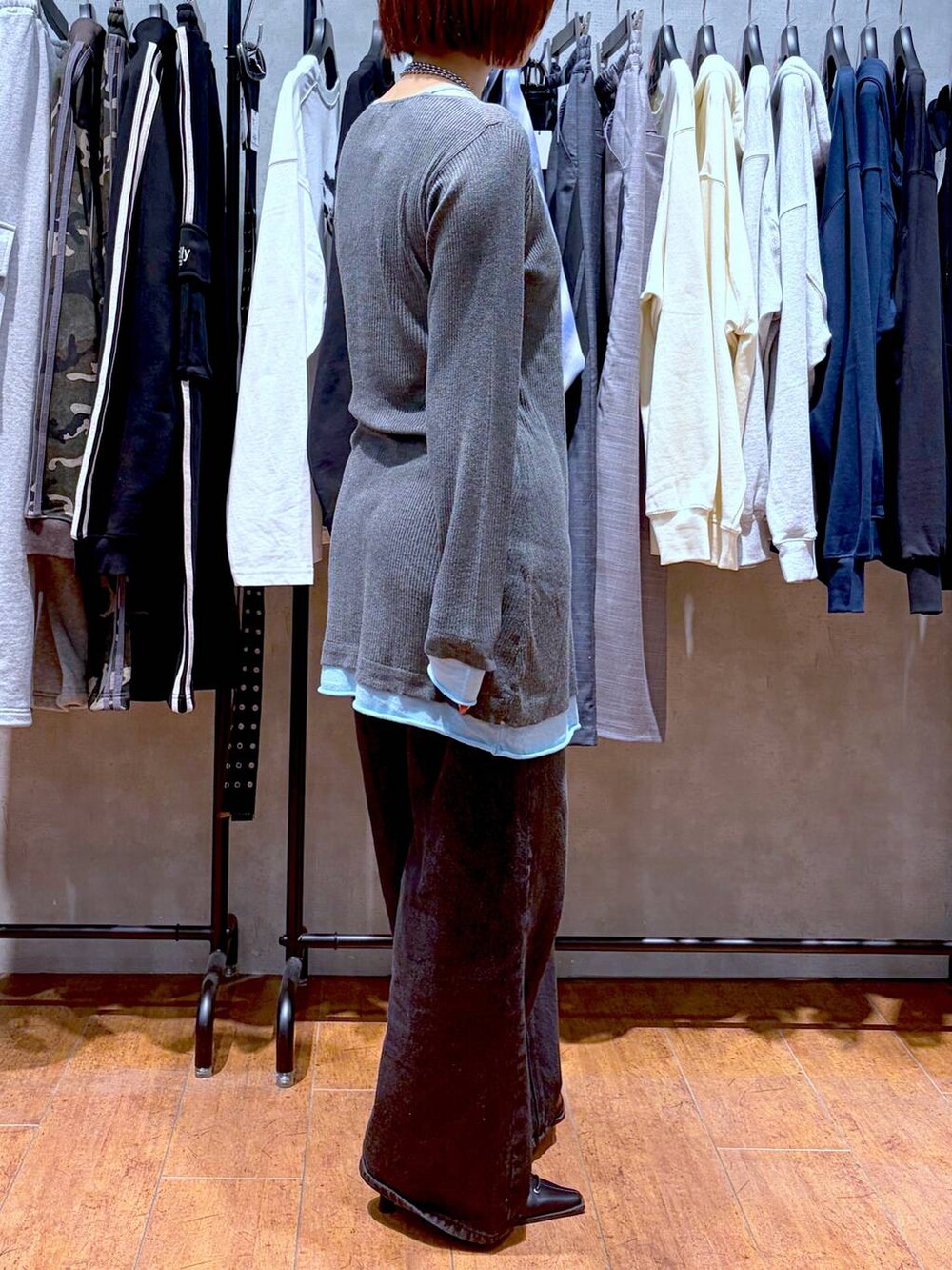 ブラック系のスラックス、ブラック系のサンダル、グレー系のチュニックを着用したレディースの春コーディネートの5枚目の写真