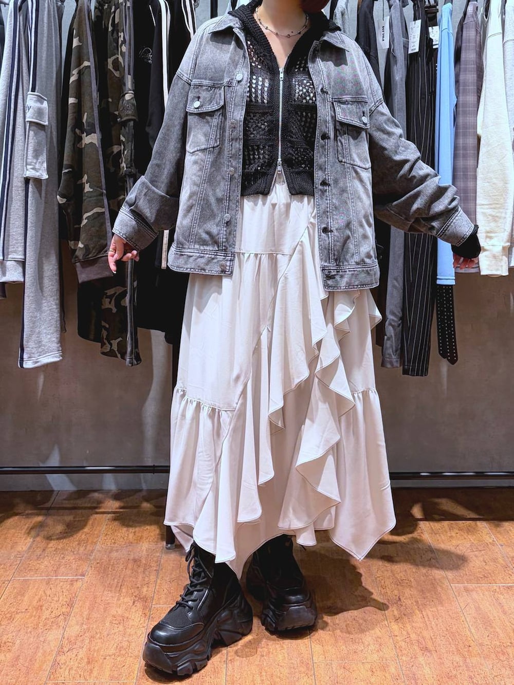 ブラック系のブーツ、ホワイト系のキャミソール、ベージュ系のスカートを着用したレディースの春コーディネートの8枚目の写真