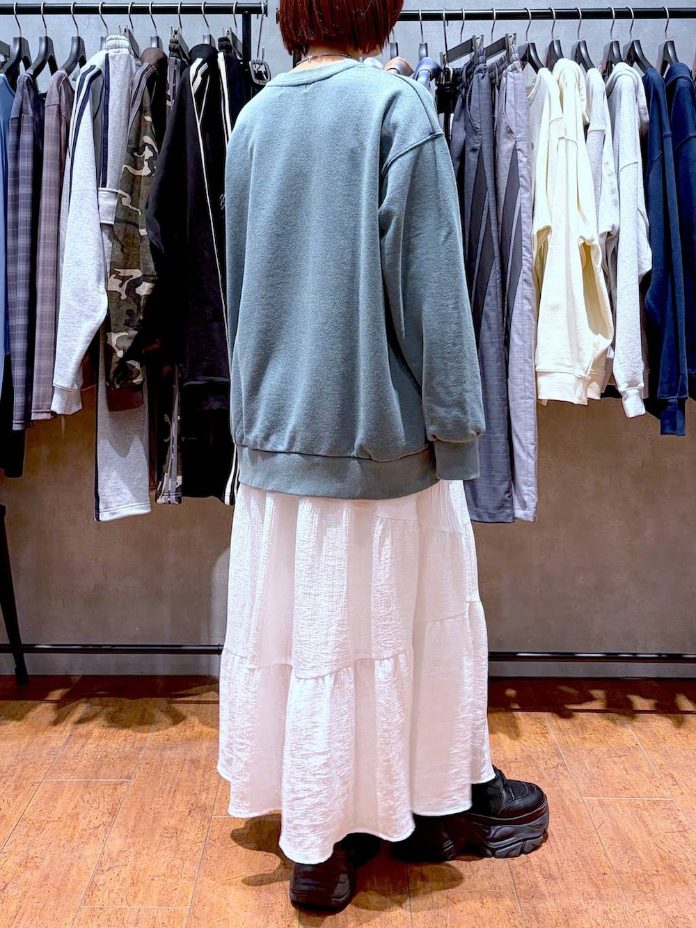 ブラック系のブーツ、グリーン系のスウェット、ホワイト系のスカートを着用したレディースの春コーディネートの5枚目の写真