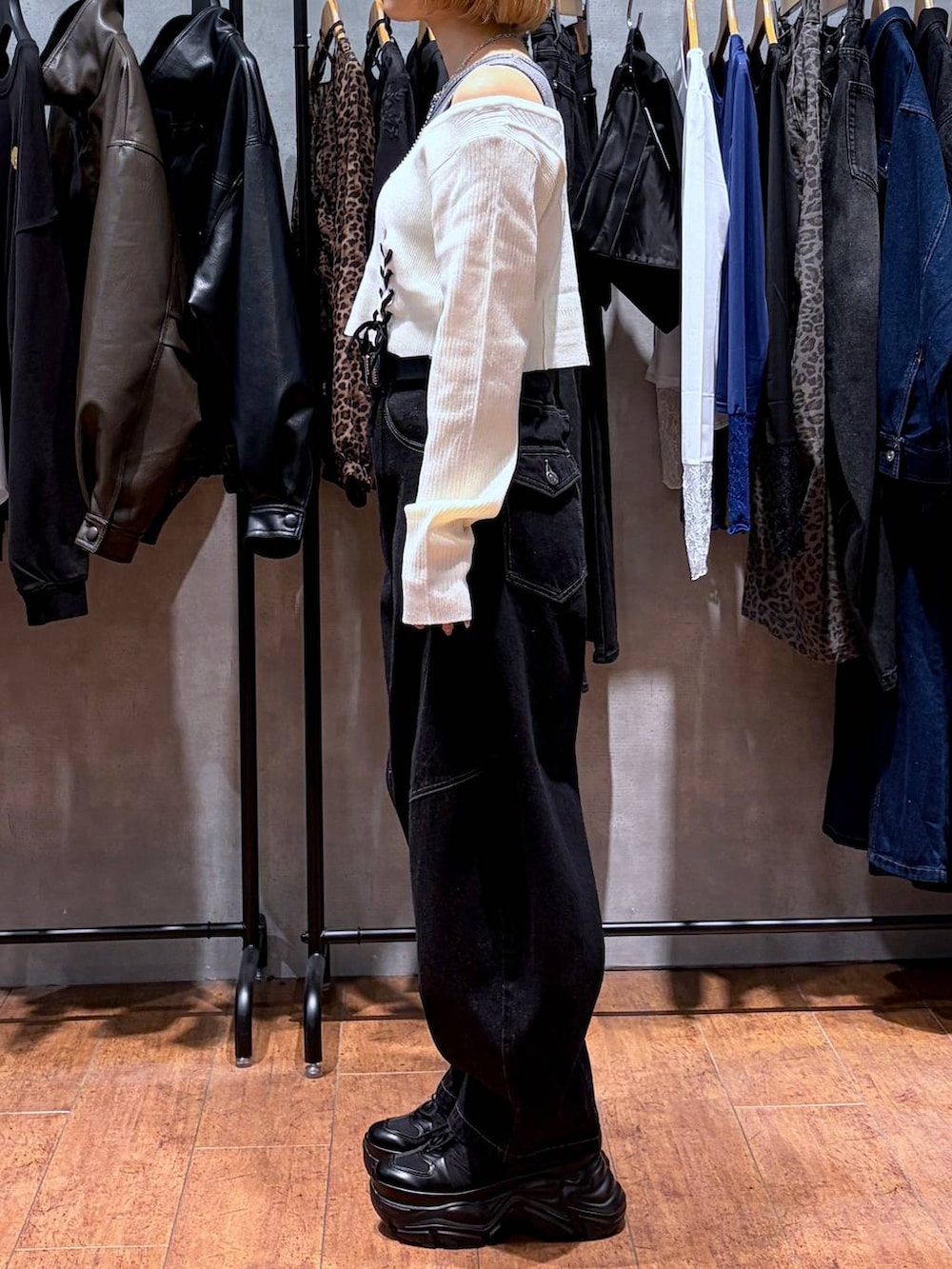 ブラック系のデニムパンツ、ブラック系のスニーカー、ホワイト系のニット/セーターを着用したレディースの秋コーディネートの2枚目の写真