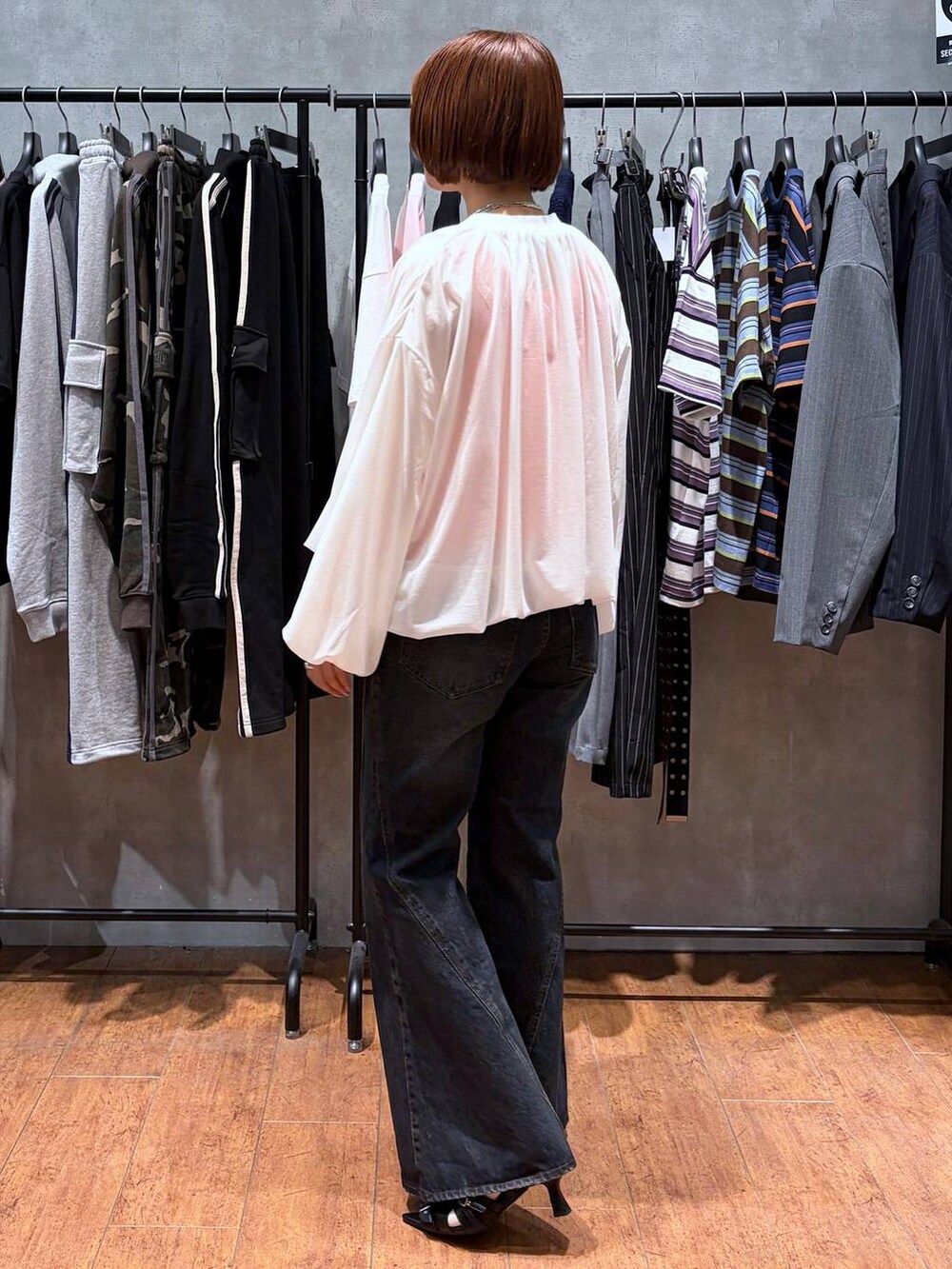 ブルー系のデニムパンツ、ホワイト系のブルゾン、ブラック系のサンダルを着用したレディースの春コーディネートの5枚目の写真