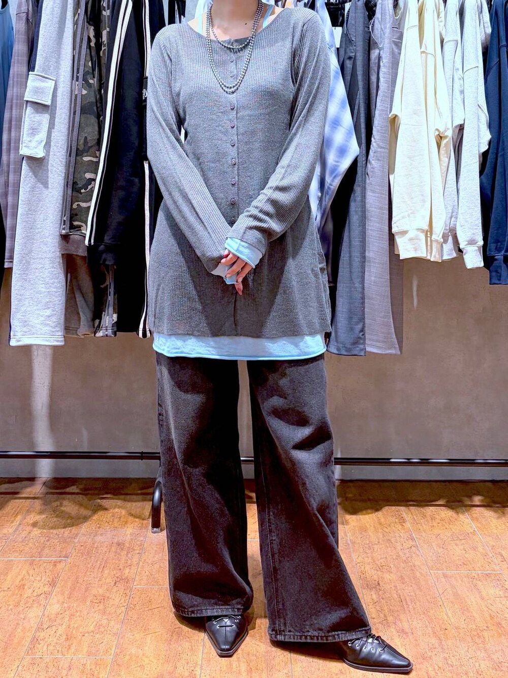 ブラック系のスラックス、ブラック系のサンダル、グレー系のチュニックを着用したレディースの春コーディネートの7枚目の写真