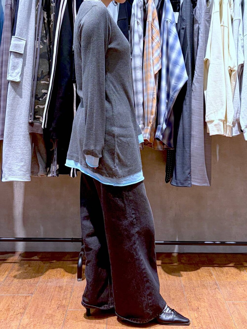 ブラック系のスラックス、ブラック系のサンダル、グレー系のチュニックを着用したレディースの春コーディネートの6枚目の写真