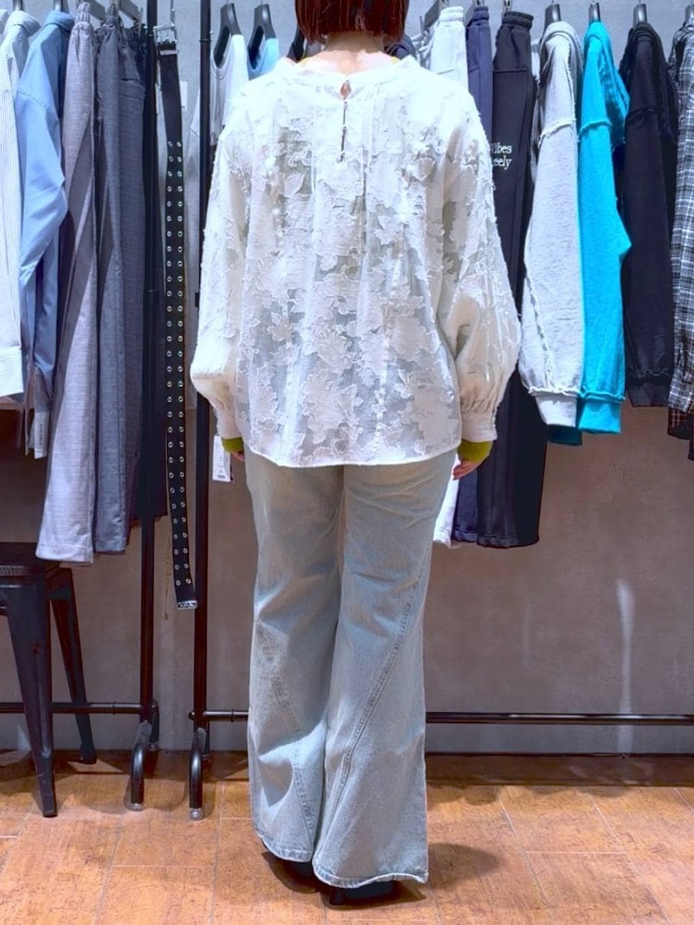 ブルー系のデニムパンツ、ホワイト系のボストンバッグ、イエロー系のニット/セーターを着用したレディースの春コーディネートの5枚目の写真