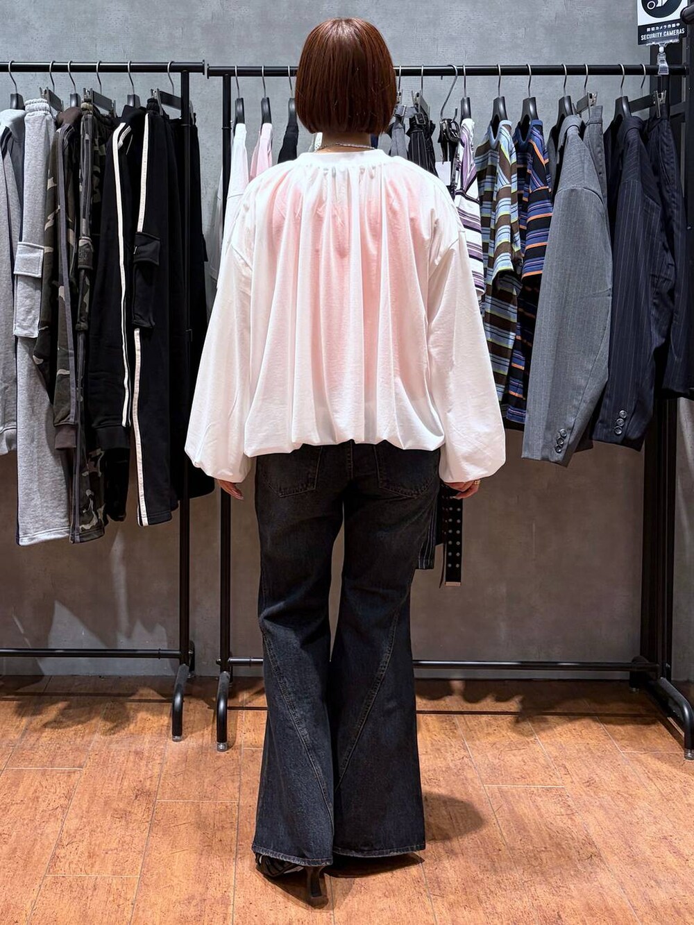 ブルー系のデニムパンツ、ホワイト系のブルゾン、ブラック系のサンダルを着用したレディースの春コーディネートの6枚目の写真