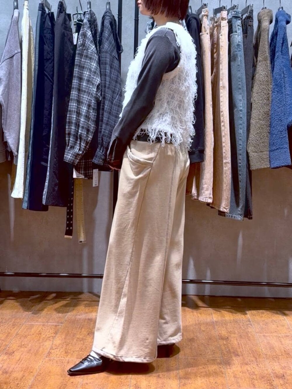 ブラック系のハンドバッグ、ブラウン系のスウェットパンツ、ブラック系のサンダルを着用したレディースの冬コーディネートの3枚目の写真