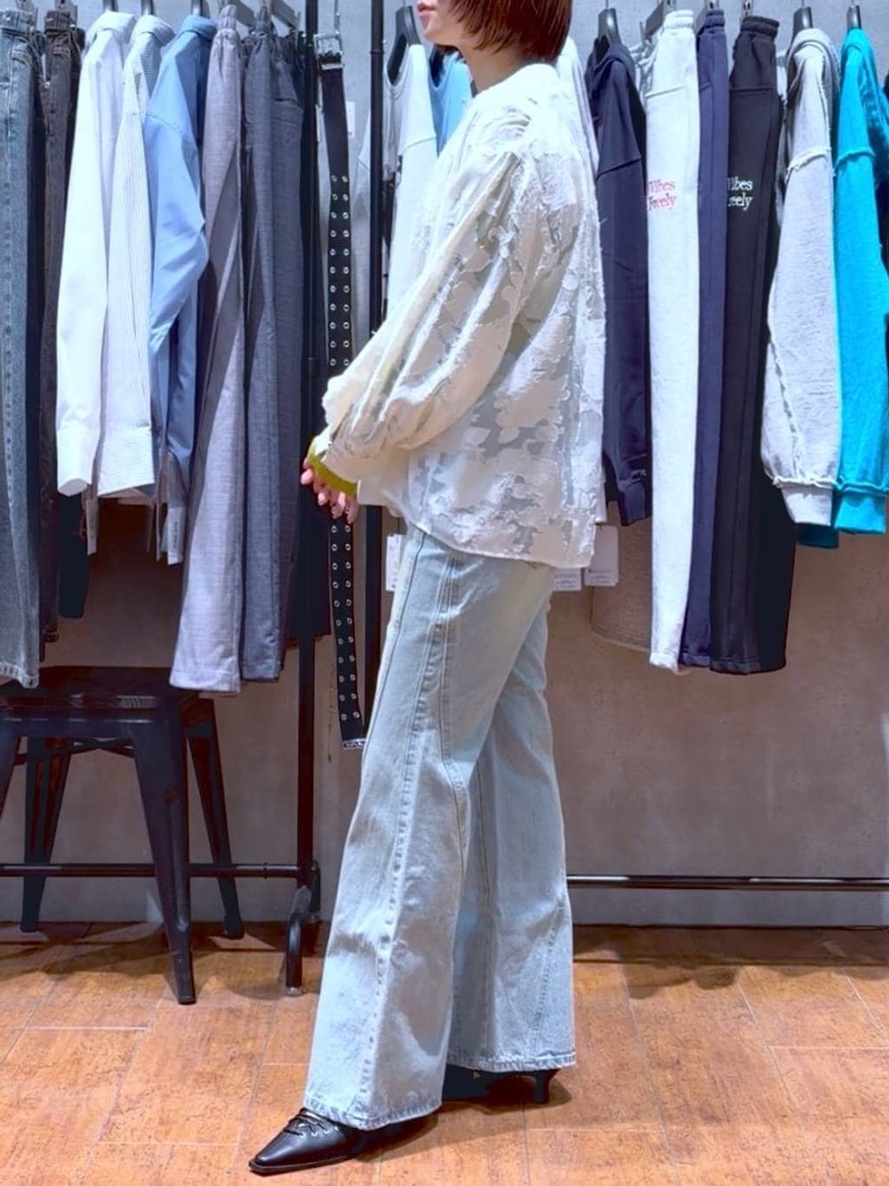 ブルー系のデニムパンツ、ホワイト系のボストンバッグ、イエロー系のニット/セーターを着用したレディースの春コーディネートの4枚目の写真