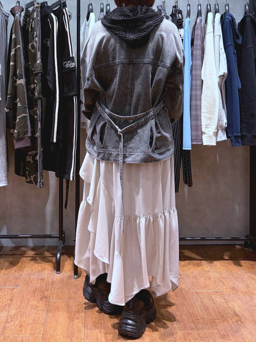 ブラック系のブーツ、ホワイト系のキャミソール、ベージュ系のスカートを着用したレディースの春コーディネートの6枚目の写真