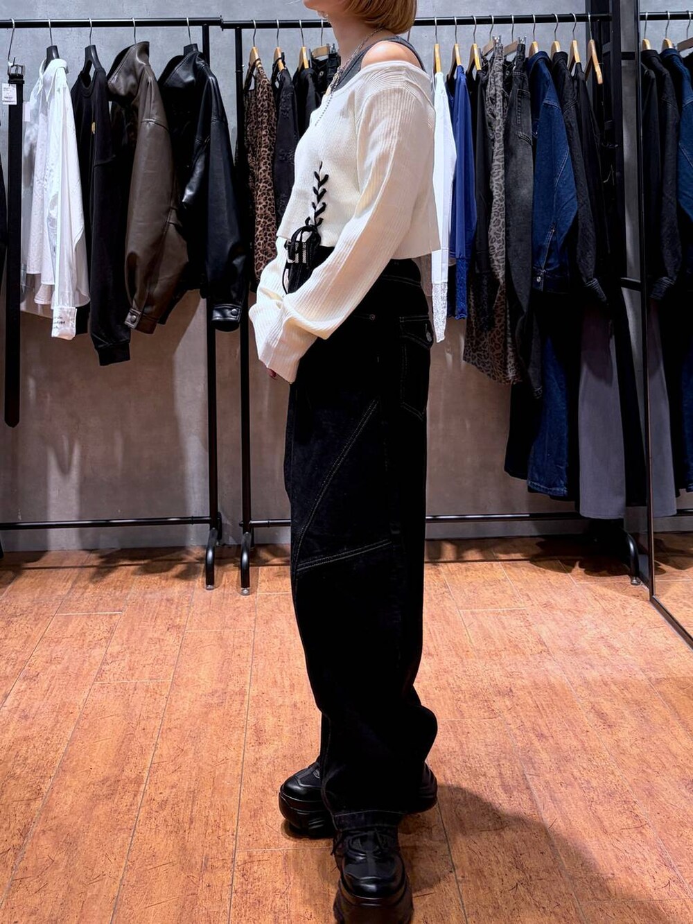 ブラック系のデニムパンツ、ブラック系のスニーカー、ホワイト系のニット/セーターを着用したレディースの秋コーディネートの7枚目の写真