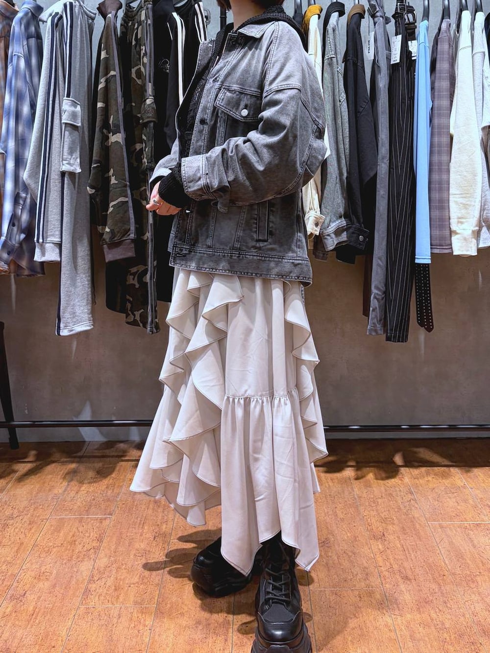 ブラック系のブーツ、ホワイト系のキャミソール、ベージュ系のスカートを着用したレディースの春コーディネートの2枚目の写真