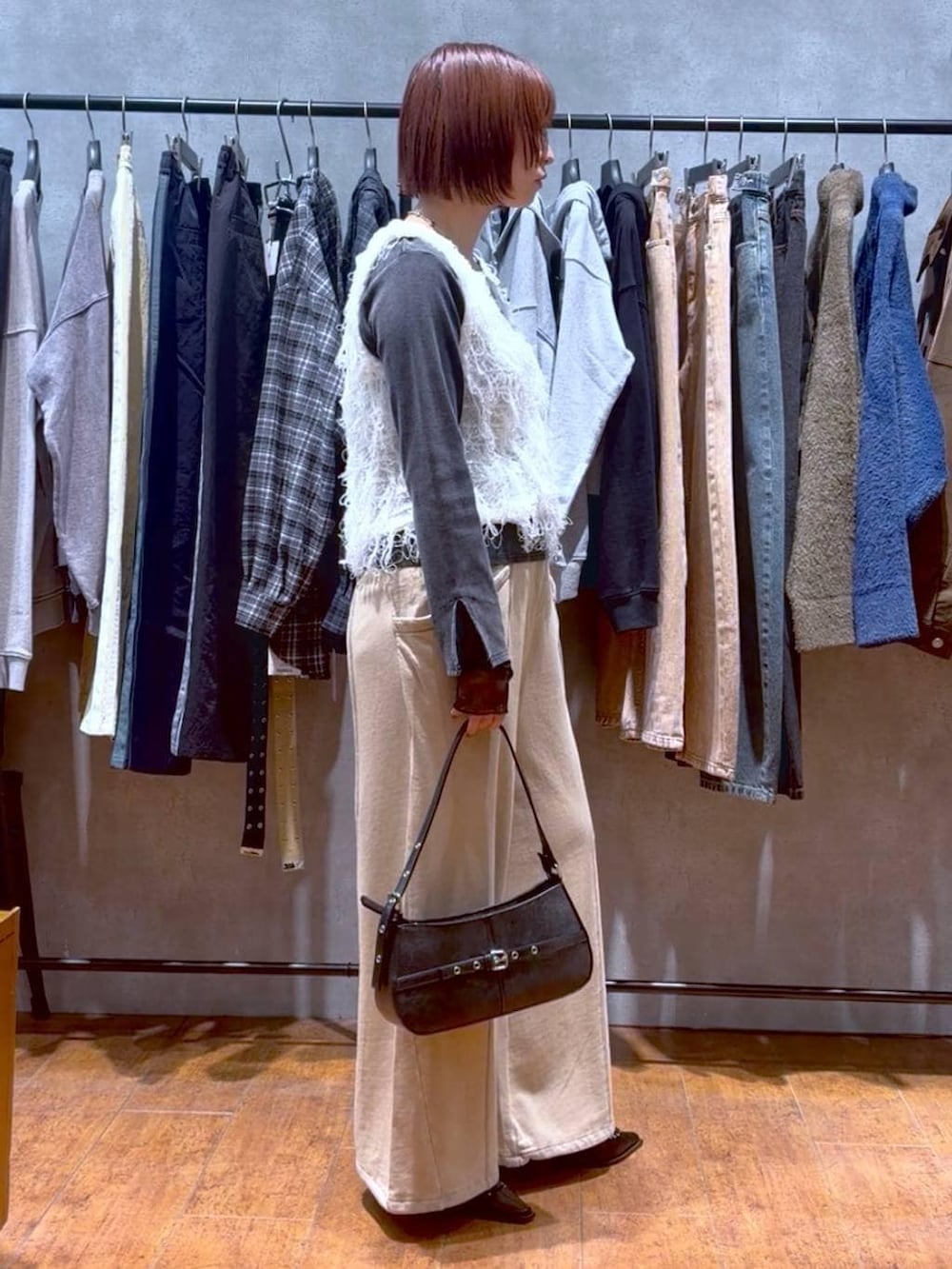 ブラック系のハンドバッグ、ブラウン系のスウェットパンツ、ブラック系のサンダルを着用したレディースの冬コーディネートの5枚目の写真