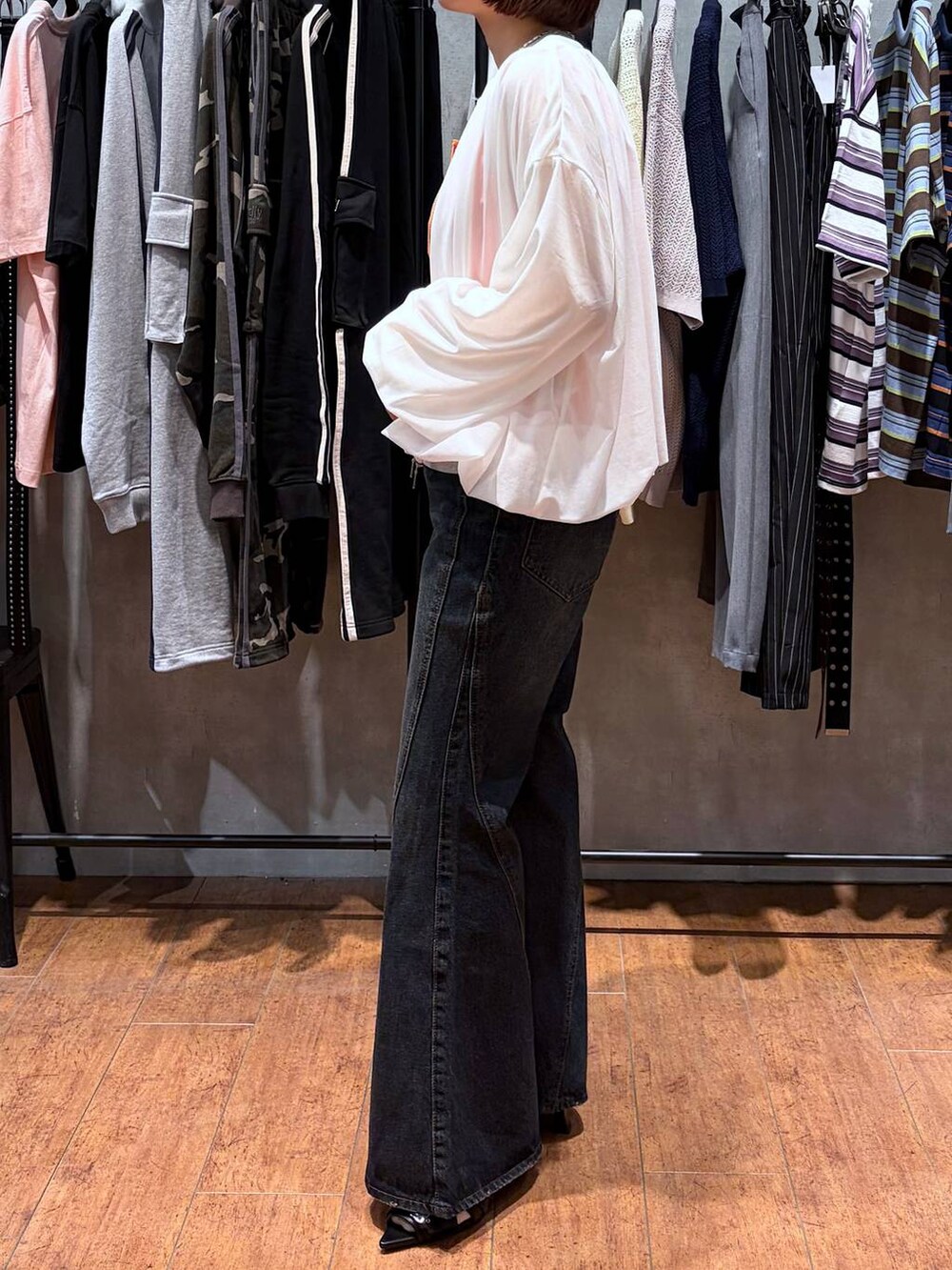 ブルー系のデニムパンツ、ホワイト系のブルゾン、ブラック系のサンダルを着用したレディースの春コーディネートの4枚目の写真