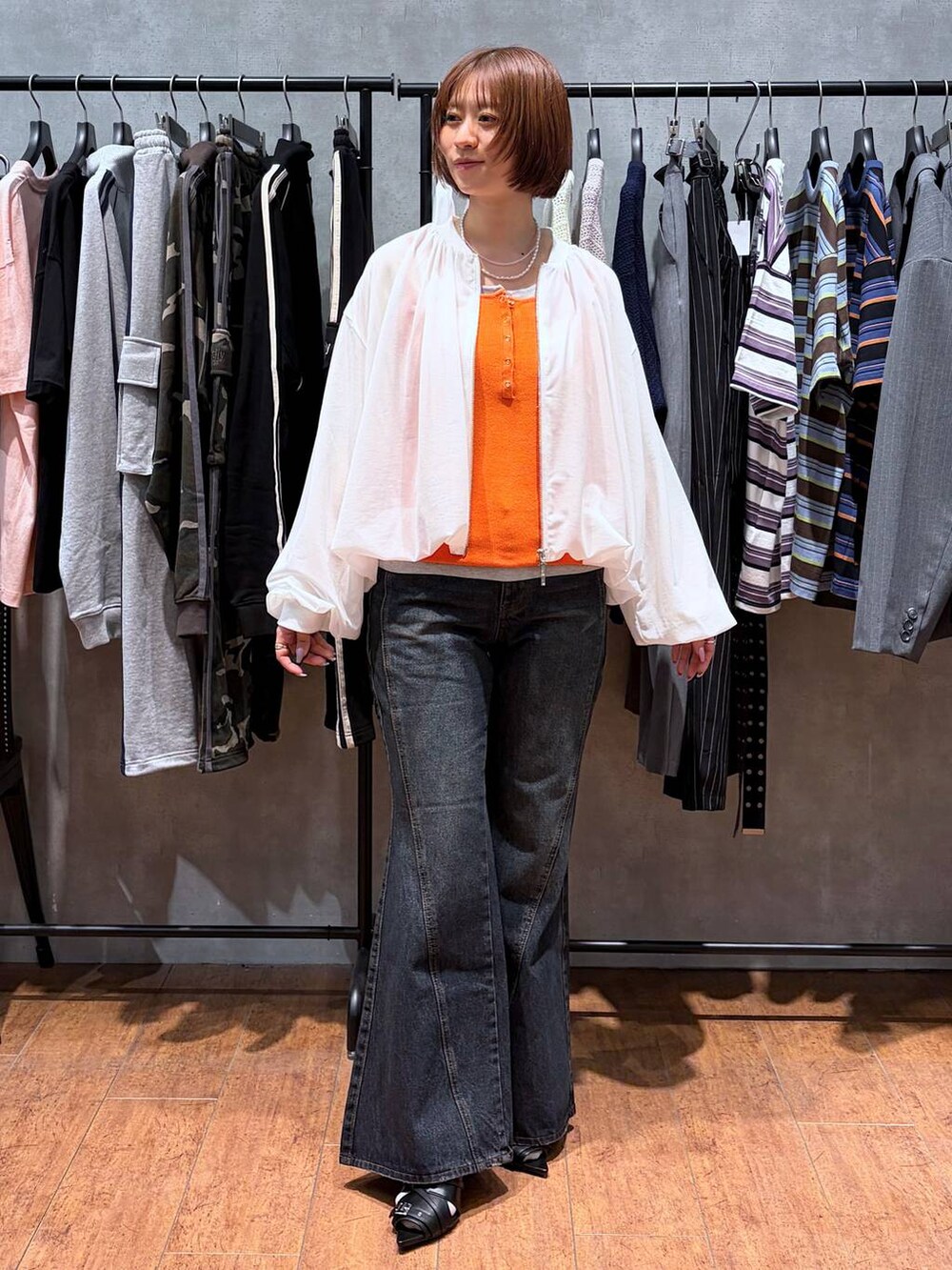 ブルー系のデニムパンツ、ホワイト系のブルゾン、ブラック系のサンダルを着用したレディースの春コーディネートの2枚目の写真