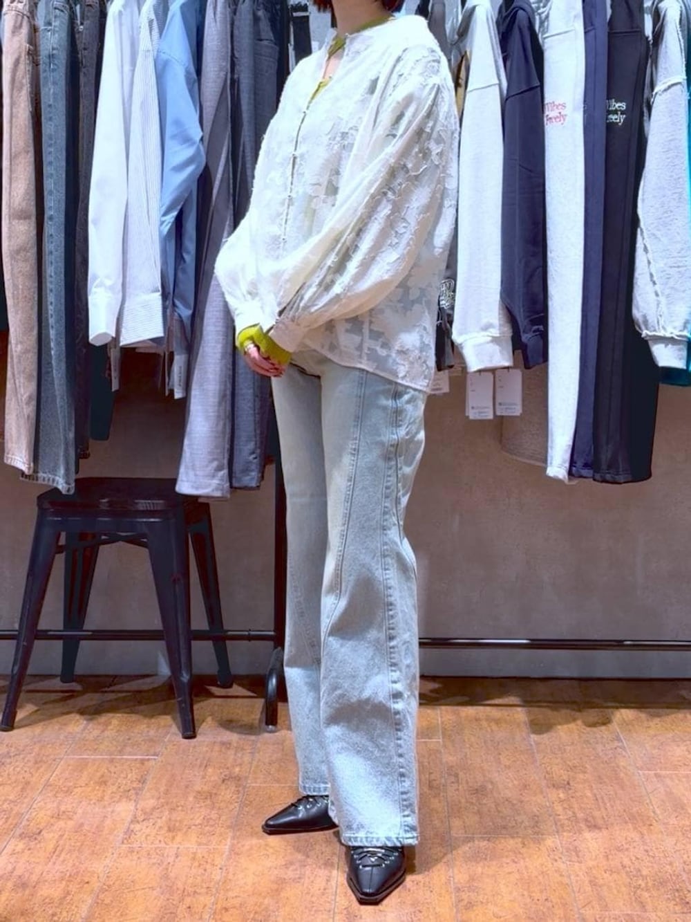 ブルー系のデニムパンツ、ホワイト系のボストンバッグ、イエロー系のニット/セーターを着用したレディースの春コーディネートの3枚目の写真