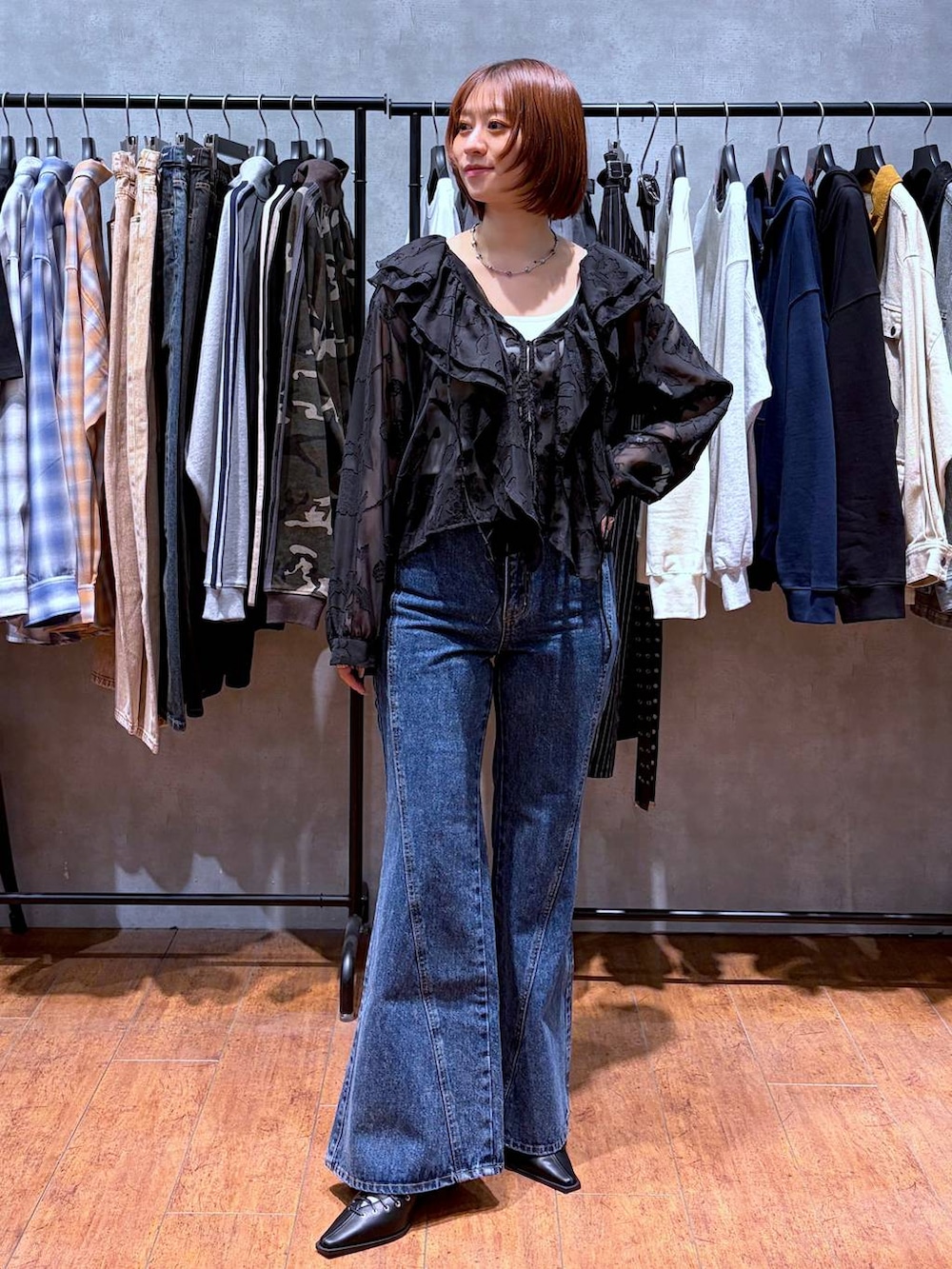 ホワイト系のキャミソール、ブルー系のデニムパンツ、ブラック系のサンダルを着用したレディースの春コーディネートの2枚目の写真