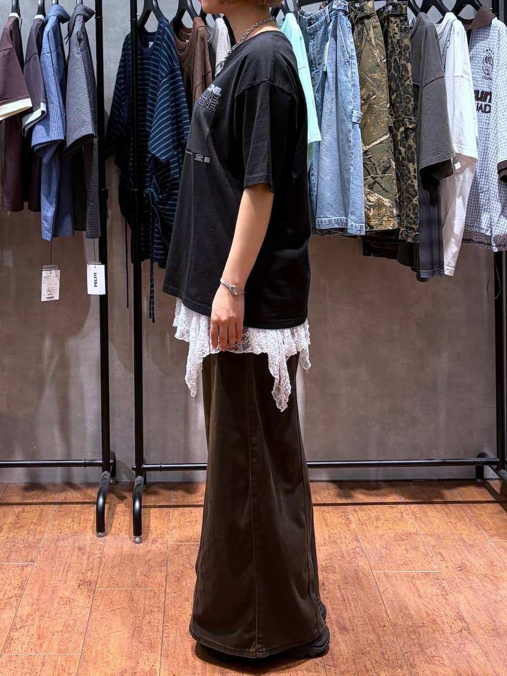 ブラウン系のデニムパンツ、ブラック系のTシャツ/カットソー、ブラック系のブーツを着用したレディースの夏コーディネートの4枚目の写真