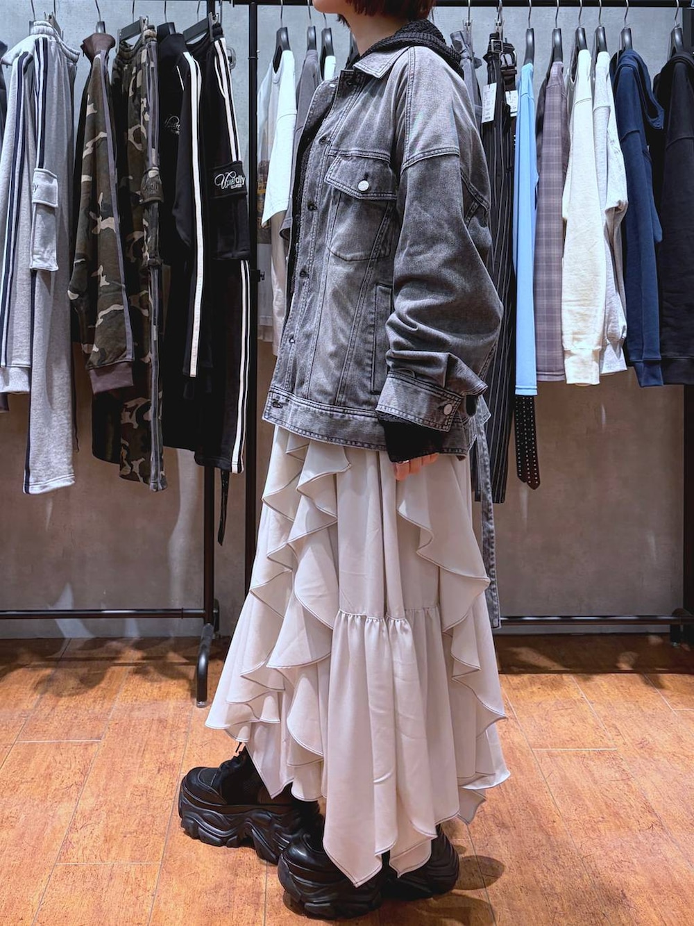 ブラック系のブーツ、ホワイト系のキャミソール、ベージュ系のスカートを着用したレディースの春コーディネートの4枚目の写真