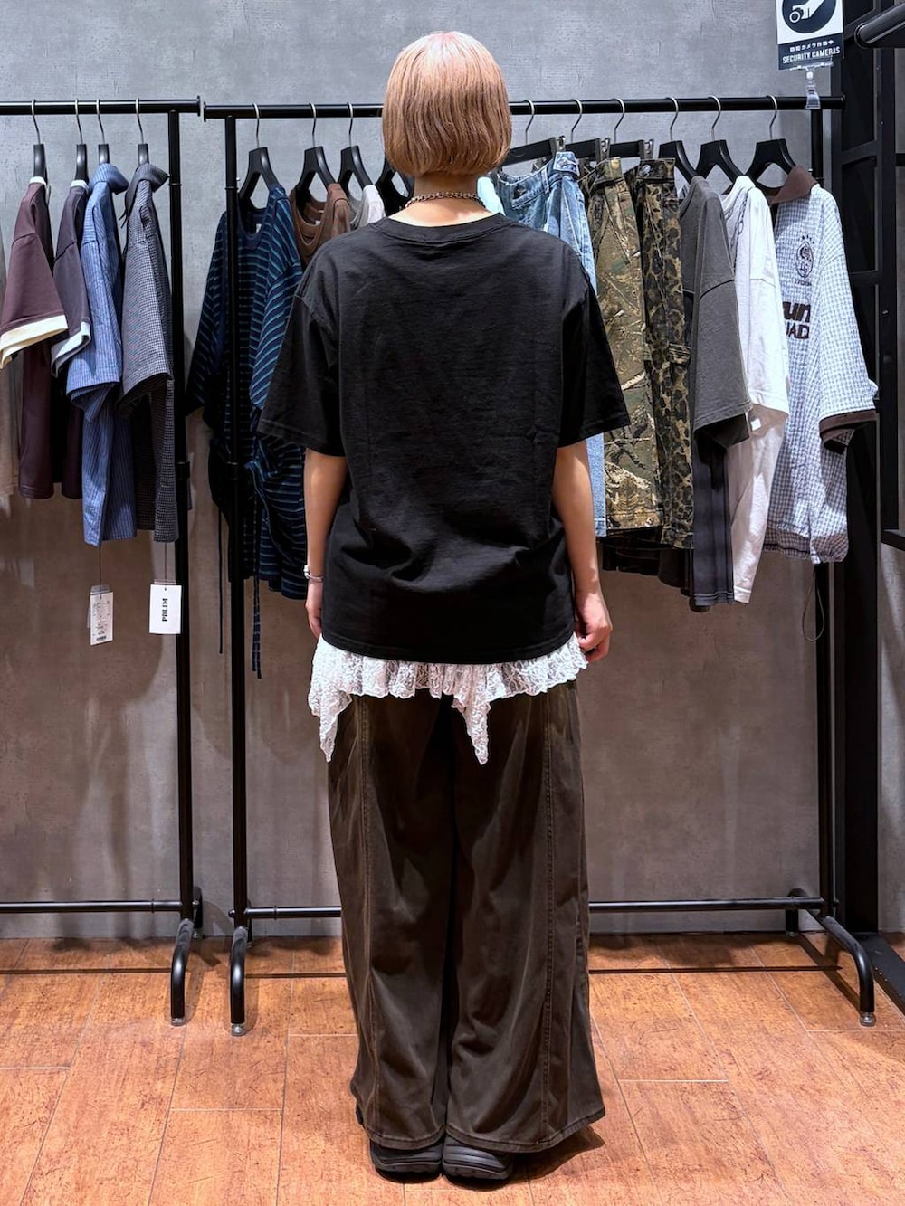 ブラウン系のデニムパンツ、ブラック系のTシャツ/カットソー、ブラック系のブーツを着用したレディースの夏コーディネートの6枚目の写真