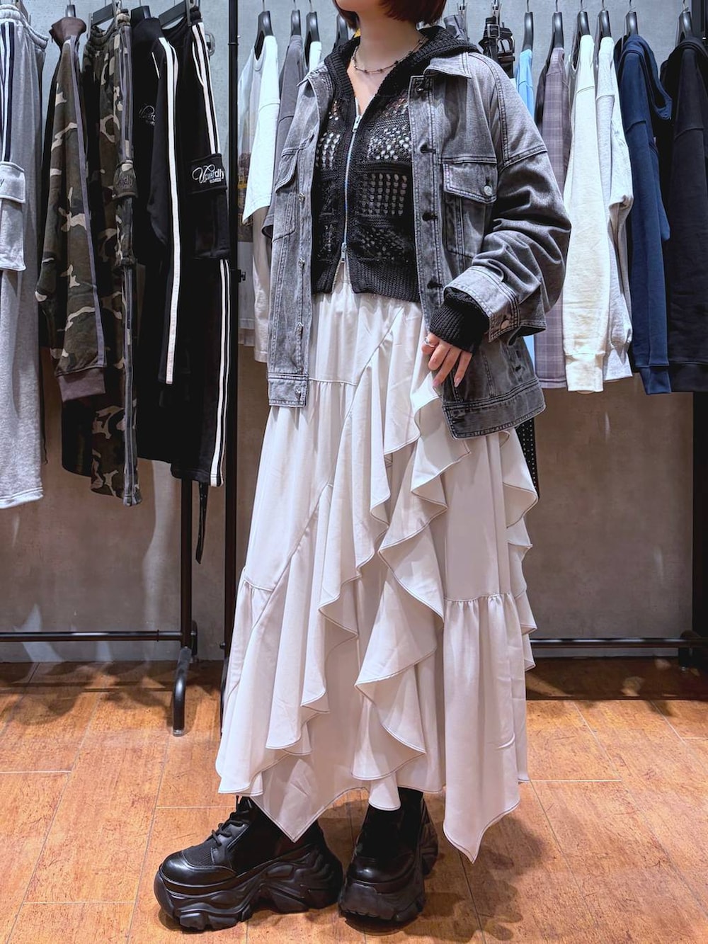 ブラック系のブーツ、ホワイト系のキャミソール、ベージュ系のスカートを着用したレディースの春コーディネートの3枚目の写真