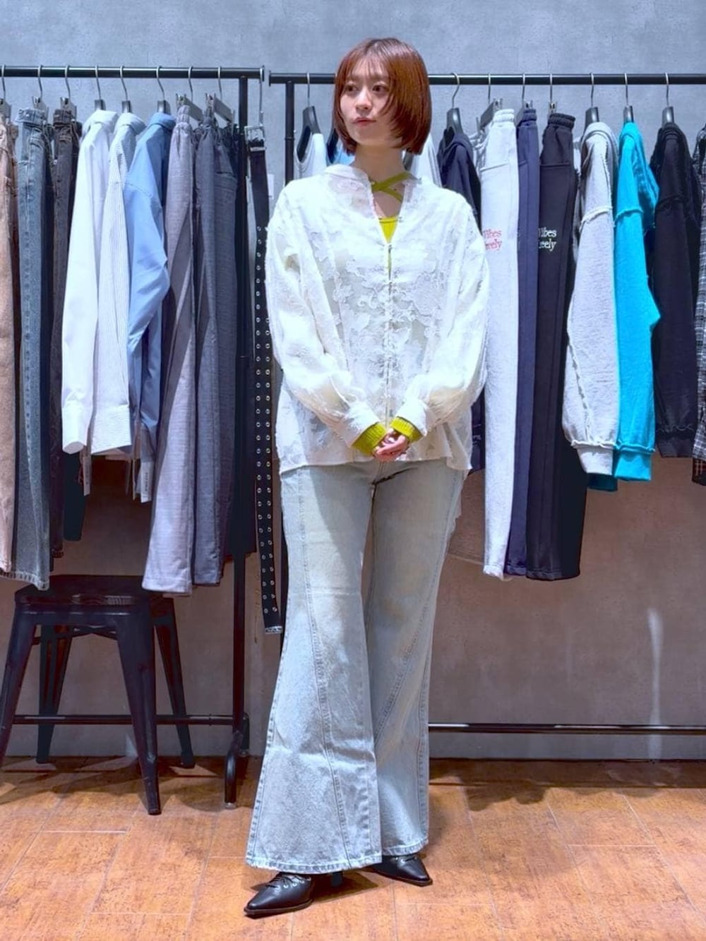 ブルー系のデニムパンツ、ホワイト系のボストンバッグ、イエロー系のニット/セーターを着用したレディースの春コーディネートの2枚目の写真