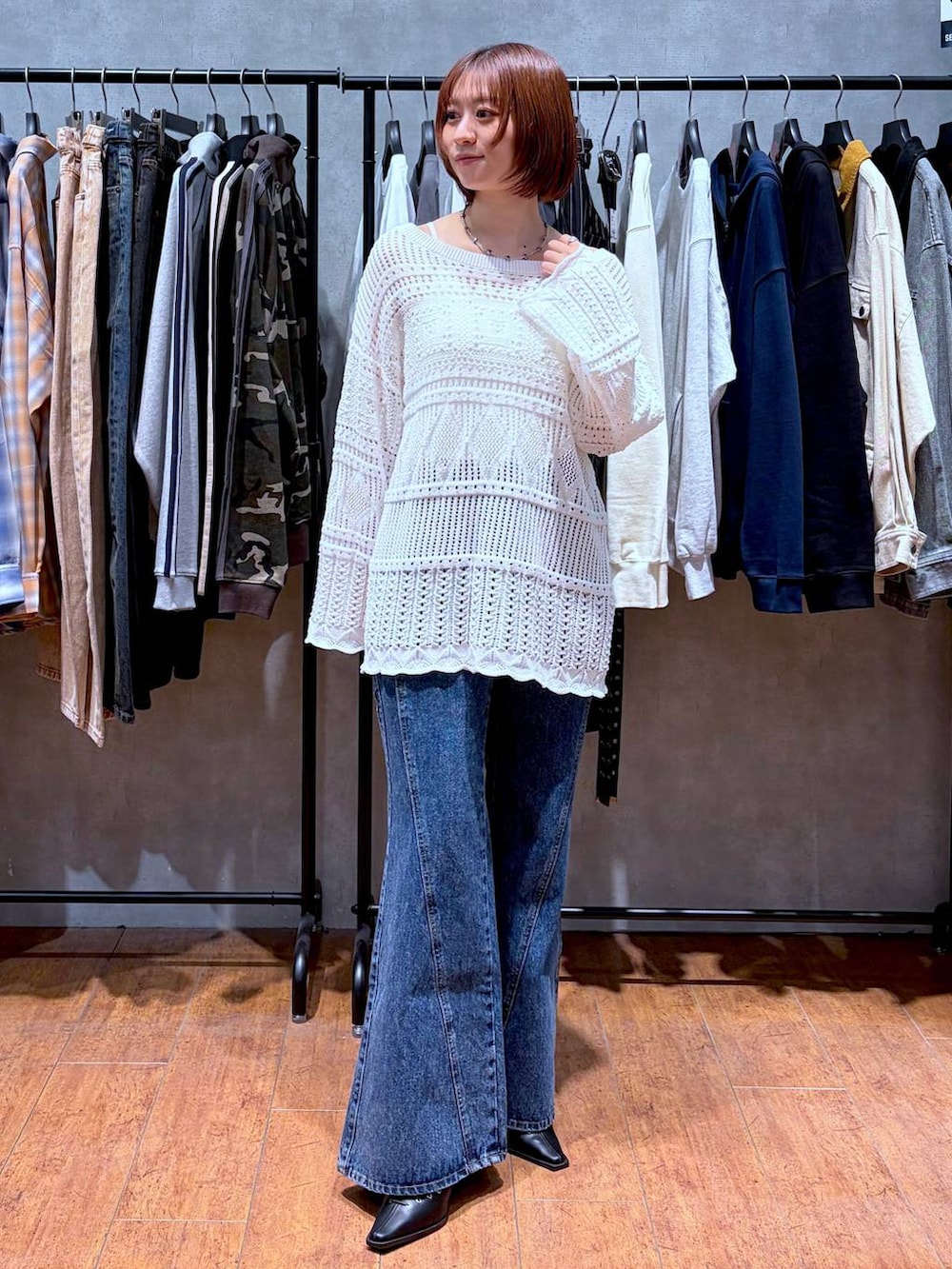 ホワイト系のキャミソール、ブルー系のデニムパンツ、ブラック系のサンダルを着用したレディースの春コーディネートの2枚目の写真