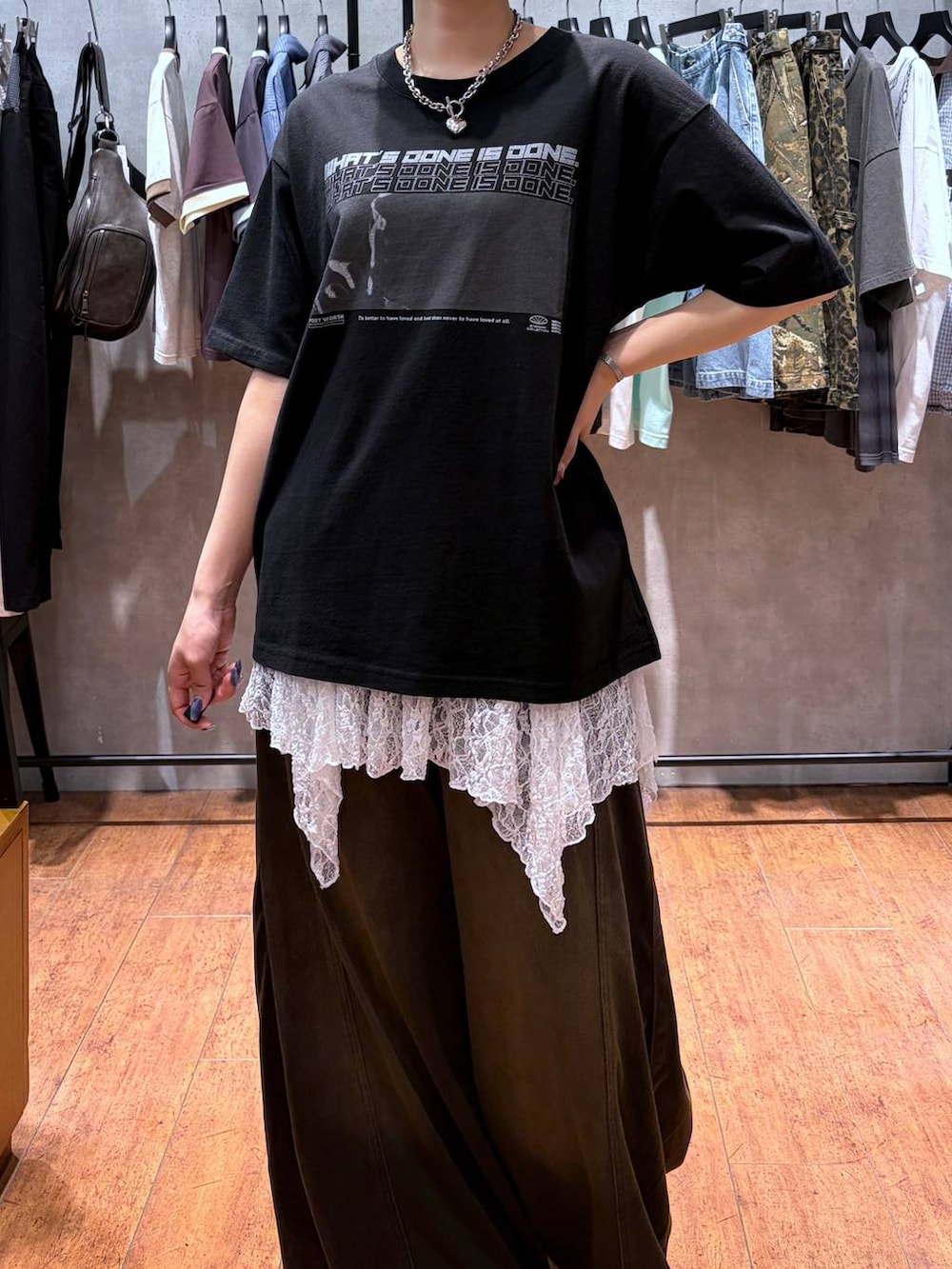 ブラウン系のデニムパンツ、ブラック系のTシャツ/カットソー、ブラック系のブーツを着用したレディースの夏コーディネートの2枚目の写真
