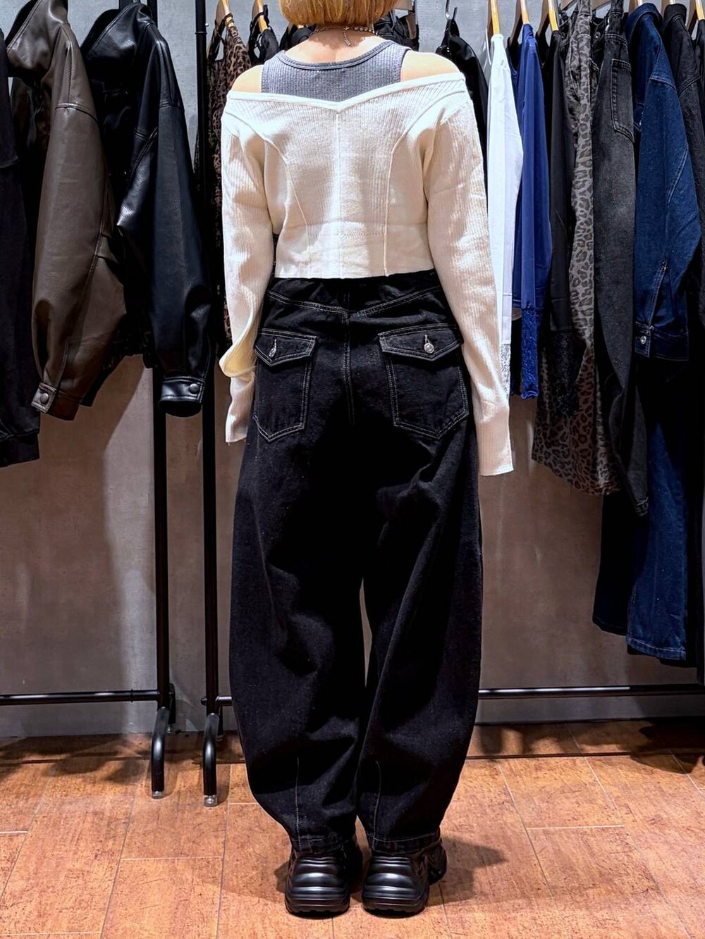 ブラック系のデニムパンツ、ブラック系のスニーカー、ホワイト系のニット/セーターを着用したレディースの秋コーディネートの4枚目の写真